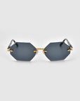 For Art's Sake® Haze sunglasses from the Rose Garden collection feature a hexagonal shape with gold frames and dark lenses on a plain grey background. The unique design offers a modern aesthetic complemented by delicate temple decorations.