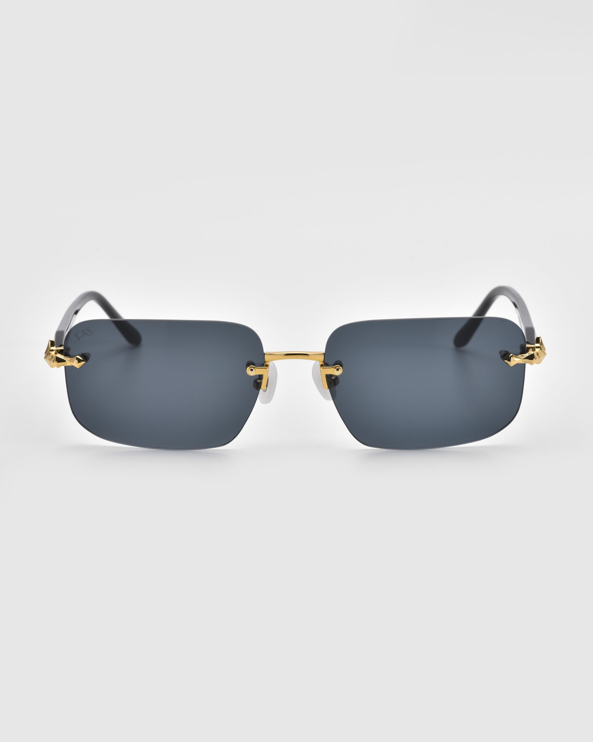 The Edith sunglasses from For Art's Sake® feature a sleek, frameless design with dark rectangular lenses and gold accents on the temples, set against a plain white background.