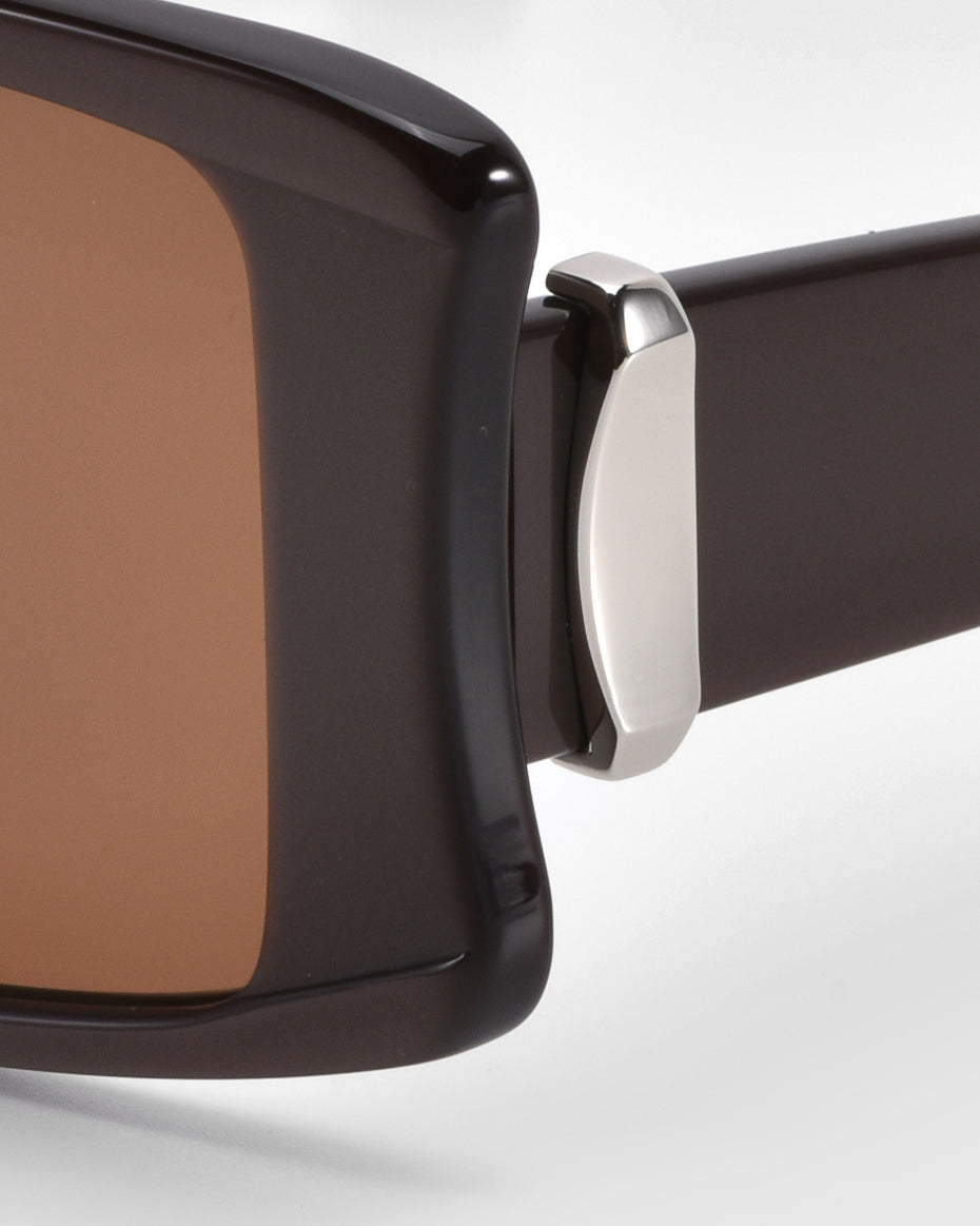 Close-up of For Art's Sake® Bloom sunglasses with oversized acetate frames, brown-tinted lenses, and sleek silver hinge against a white background.