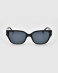 A pair of For Art's Sake® Rosie sunglasses, featuring a black rectangular design with dark lenses and small gold accents on the sides, viewed from the front against a plain white background.