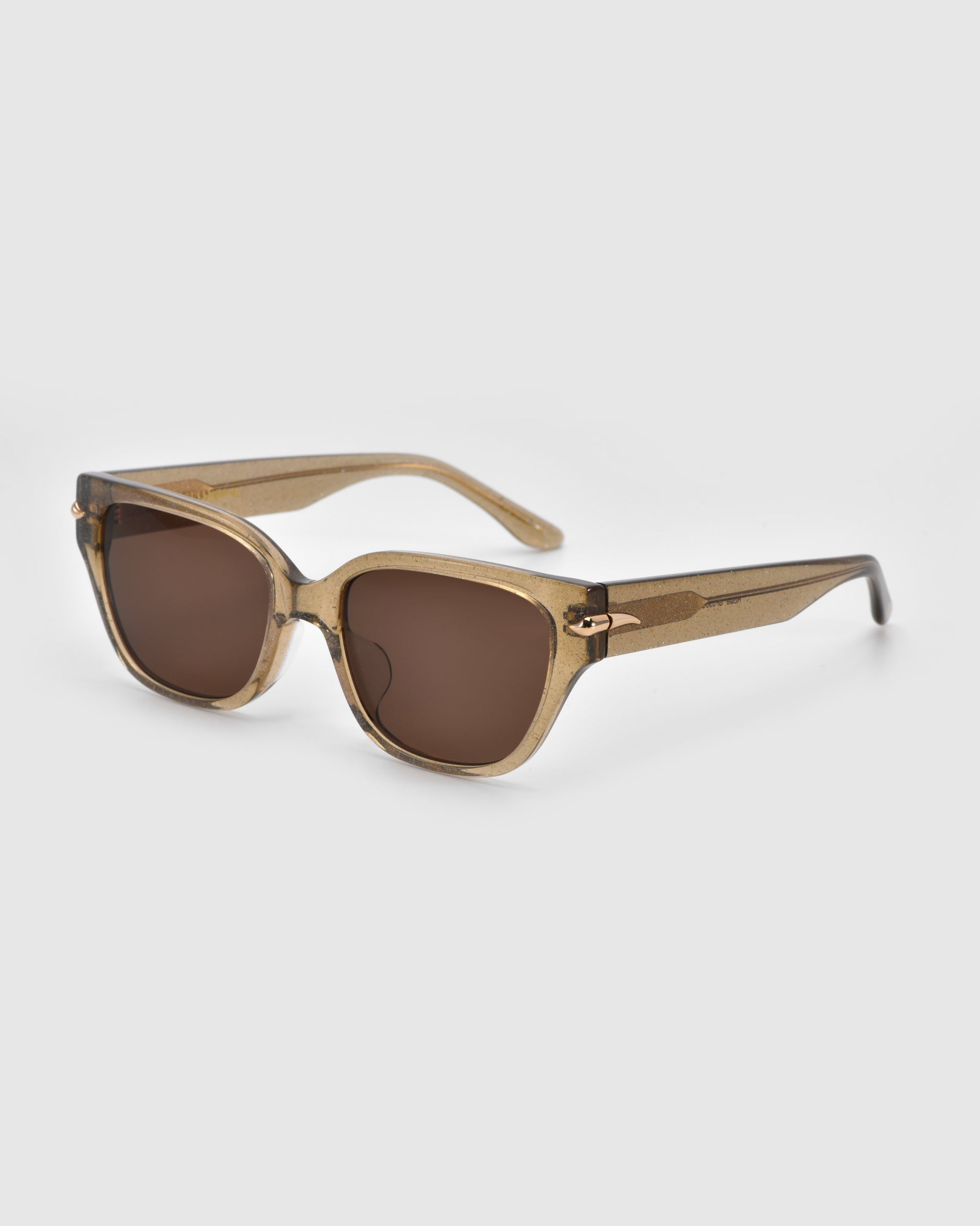 Part of the Rose Garden collection, Rosie sunglasses by For Art's Sake® feature a chic transparent acetate frame with dark brown lenses. The gradient arms transition from brown to light tan, set against a plain light gray backdrop for an everyday stylish look.