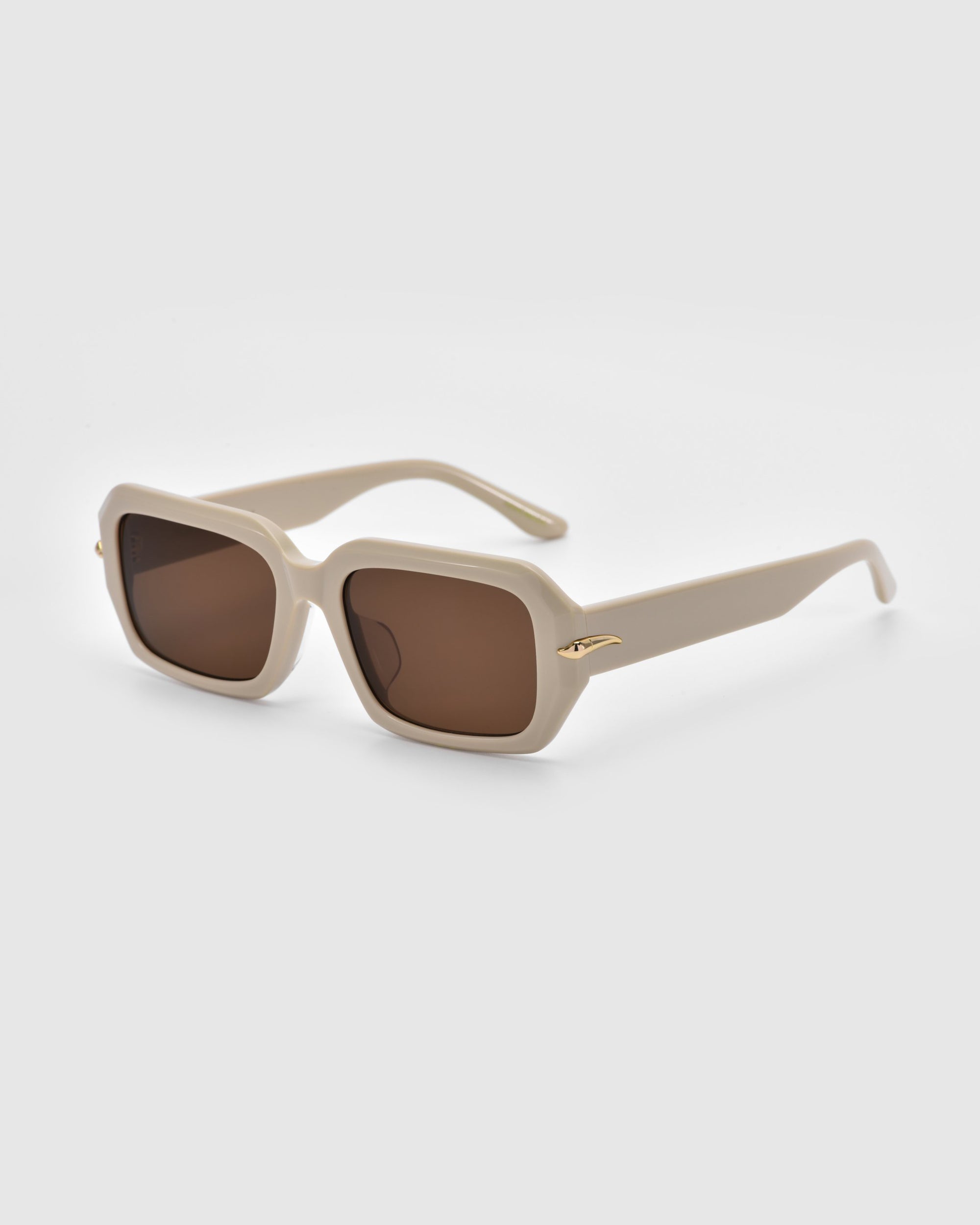 The Fleur by For Art's Sake® are beige square sunglasses with brown lenses and gold temple details, elegantly designed with an acetate frame, shown on a light gray background.