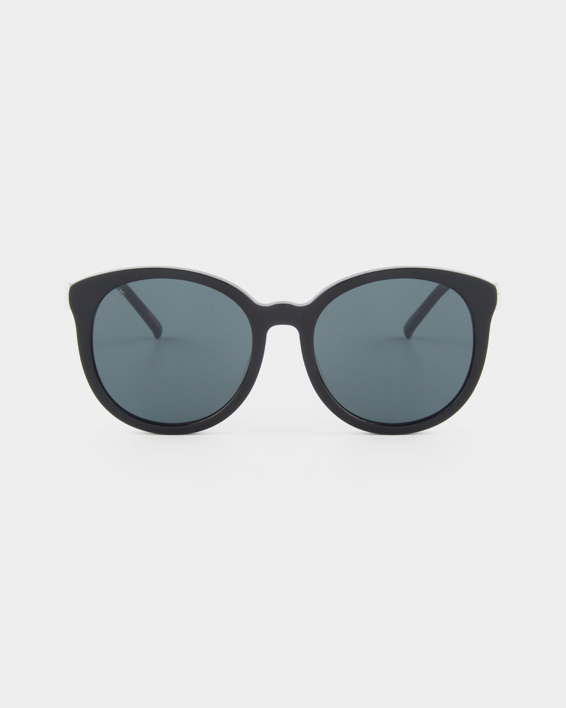 A pair of black Scarlett frames, round-frame sunglasses with shatter-resistant nylon lenses that offer UVA & UVB protection are viewed from the front against a plain white background. These are Scarlett by For Art's Sake®.