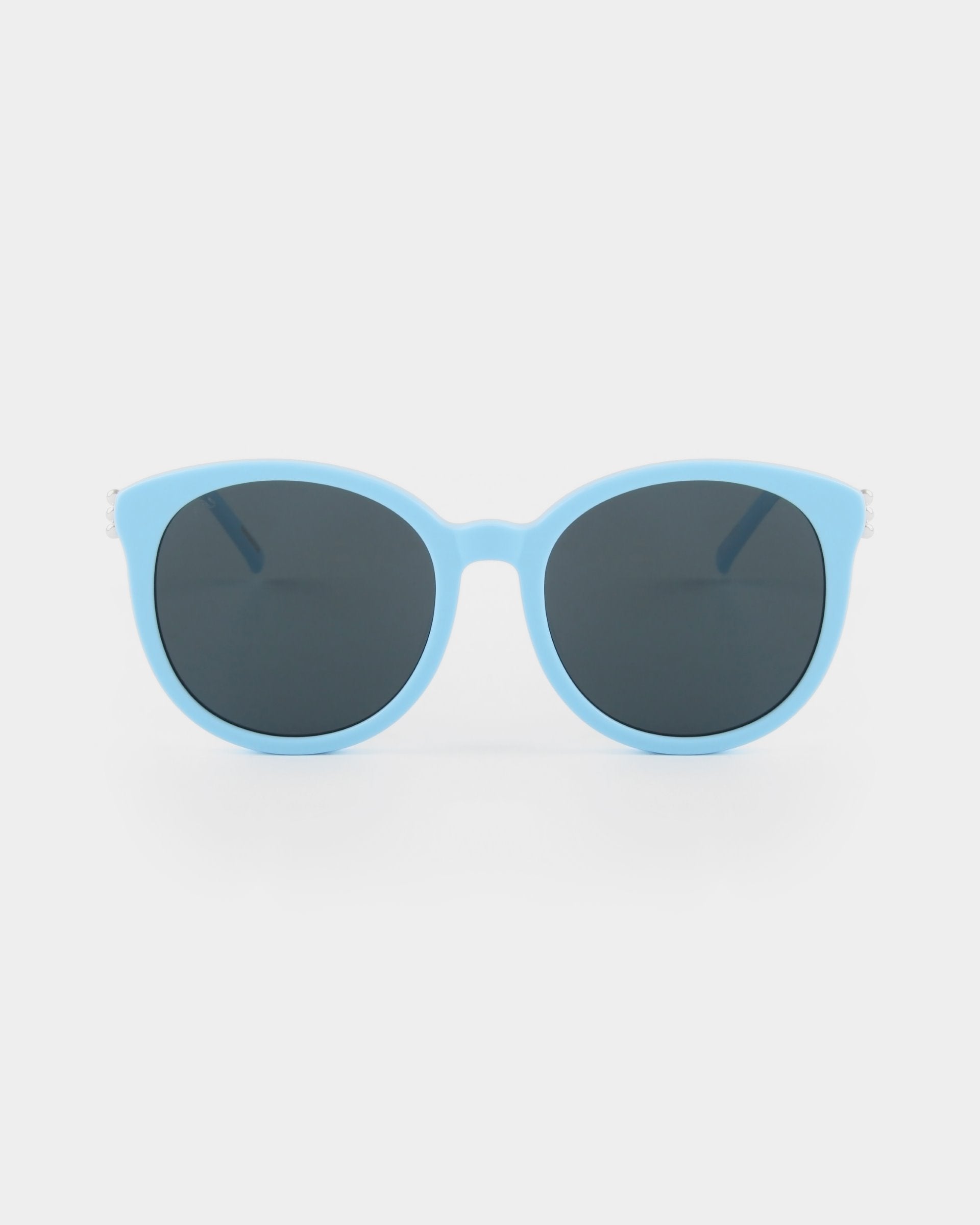A pair of stylish Scarlett sunglasses by For Art&#39;s Sake® with shatter-resistant nylon lenses that are dark and oval-shaped, displayed against a plain white background.