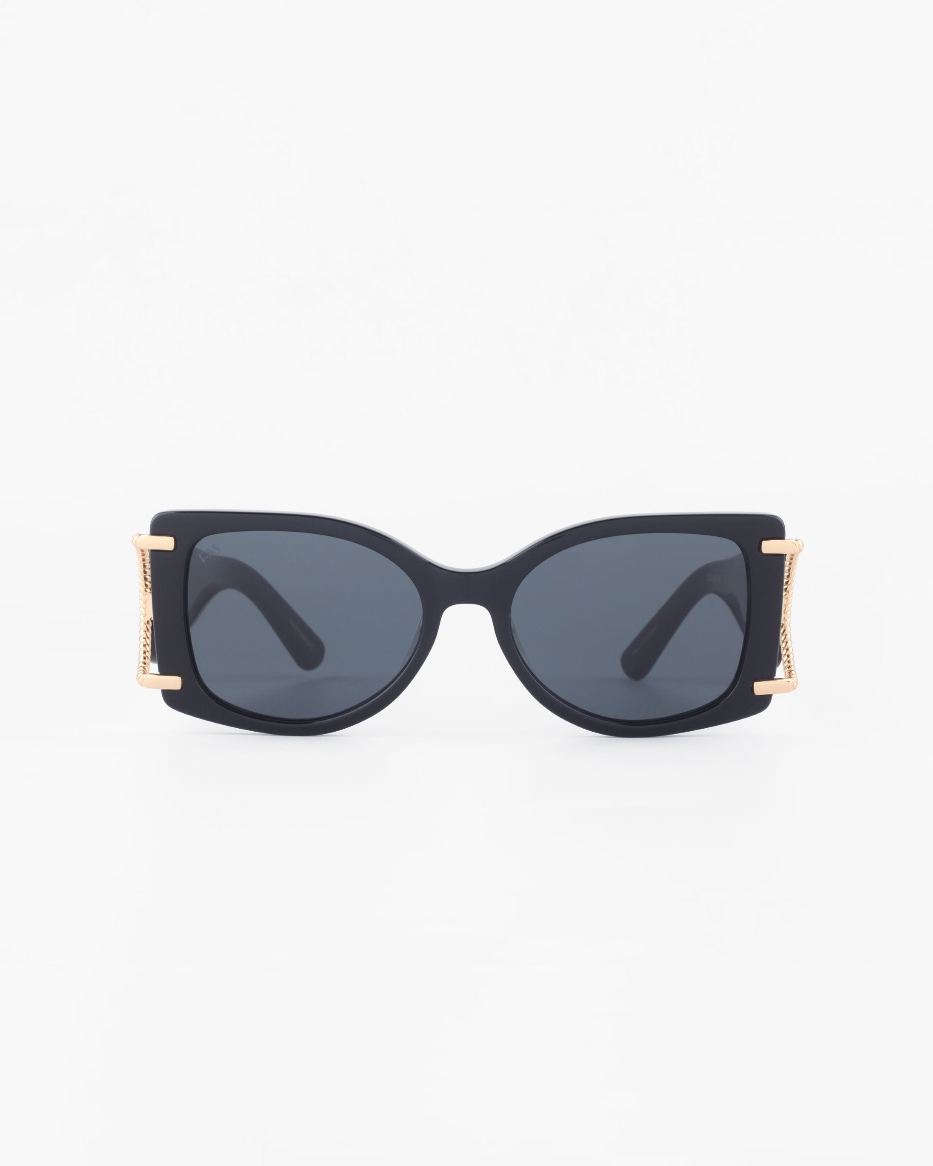 A pair of black rectangular acetate Sculpture sunglasses by For Art&#39;s Sake® with dark lenses. The frame features 18-karat gold-plated accents on the sides near the temples, adding an elegant touch. With 100% UVA &amp; UVB protection, these stylish sunglasses stand out against a plain white backdrop.