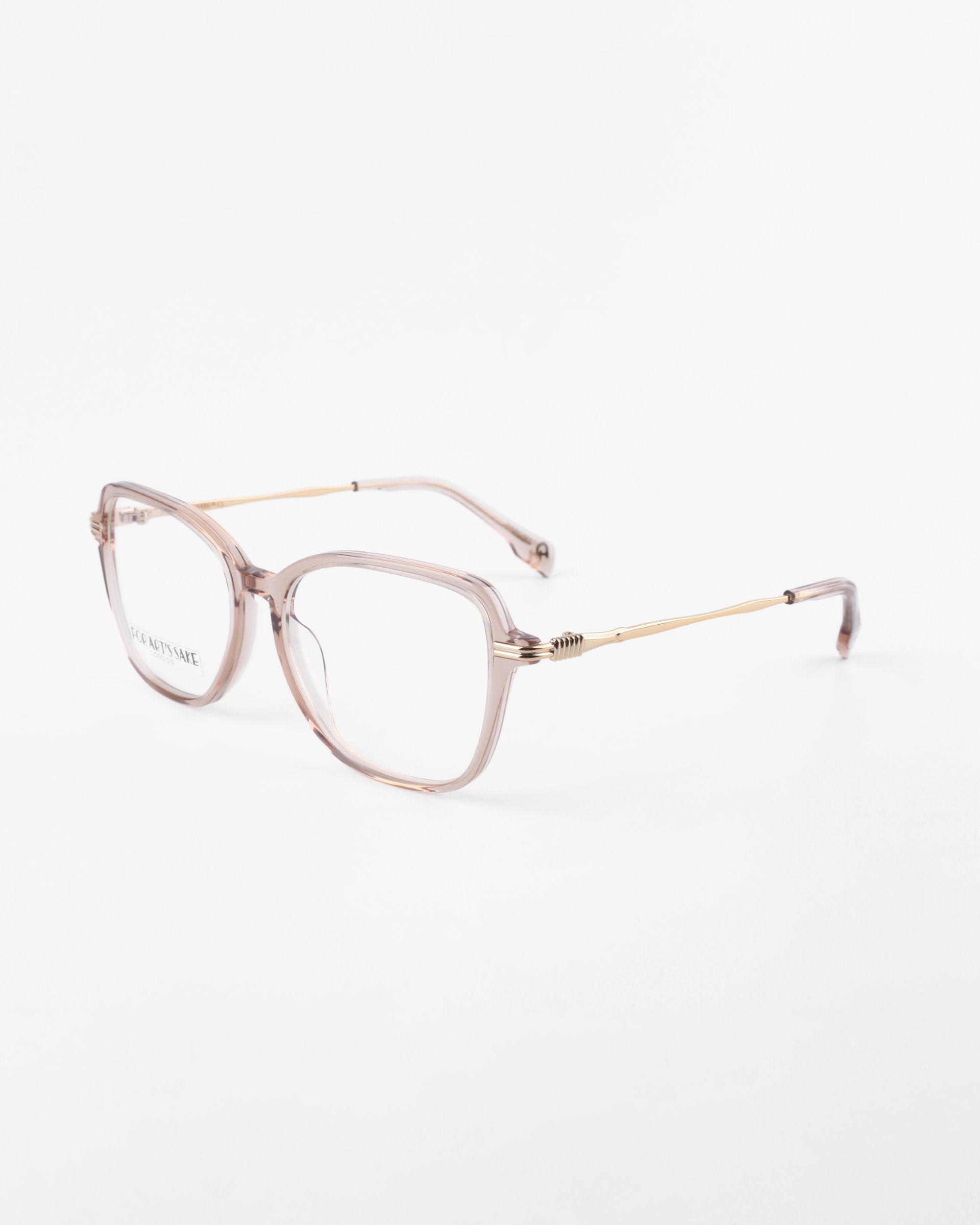 A pair of transparent, square-shaped eyeglasses with thin, 18-karat gold-plated temples and spring hinges on a plain white background. The frames have a subtle pink tint, and the ends of the temples are also pink. These stylish Sonnet glasses from For Art&#39;s Sake® come with blue light filter prescription lenses for added comfort.