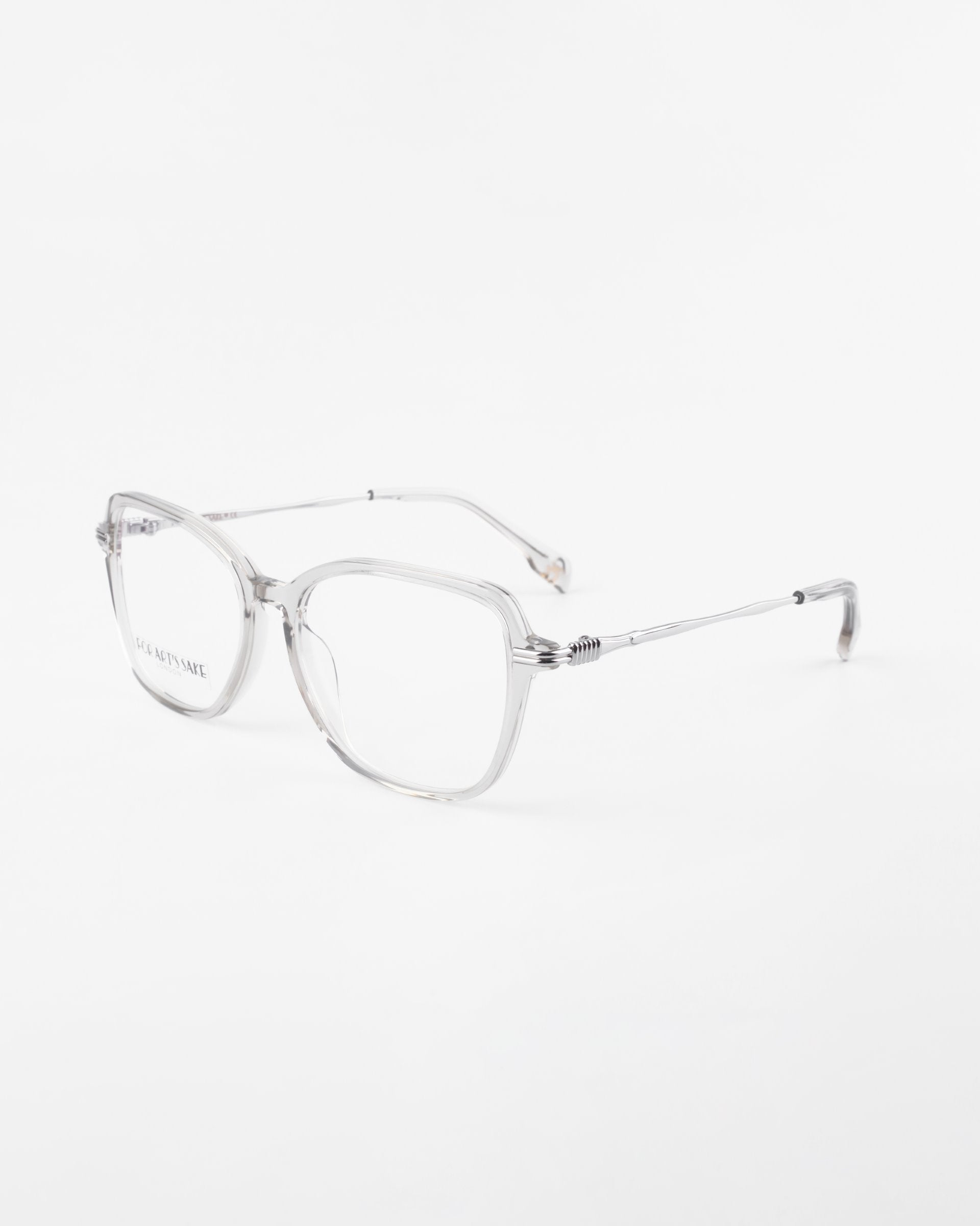 A pair of clear, square-framed eyeglasses with thin temples and a minimalist design set against a plain white background. The Sonnet by For Art&#39;s Sake® appear modern and lightweight, showcasing a streamlined and elegant aesthetic.