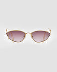 The Ornate sunglasses by For Art's Sake® are positioned against a plain white background, showcasing their stylish almond-shaped design with gold metal frames and purple-tinted lenses. Featuring a slight cat-eye shape and thin arms, these sunglasses exude a modern and sophisticated appearance while providing 100% UVA & UVB protection.