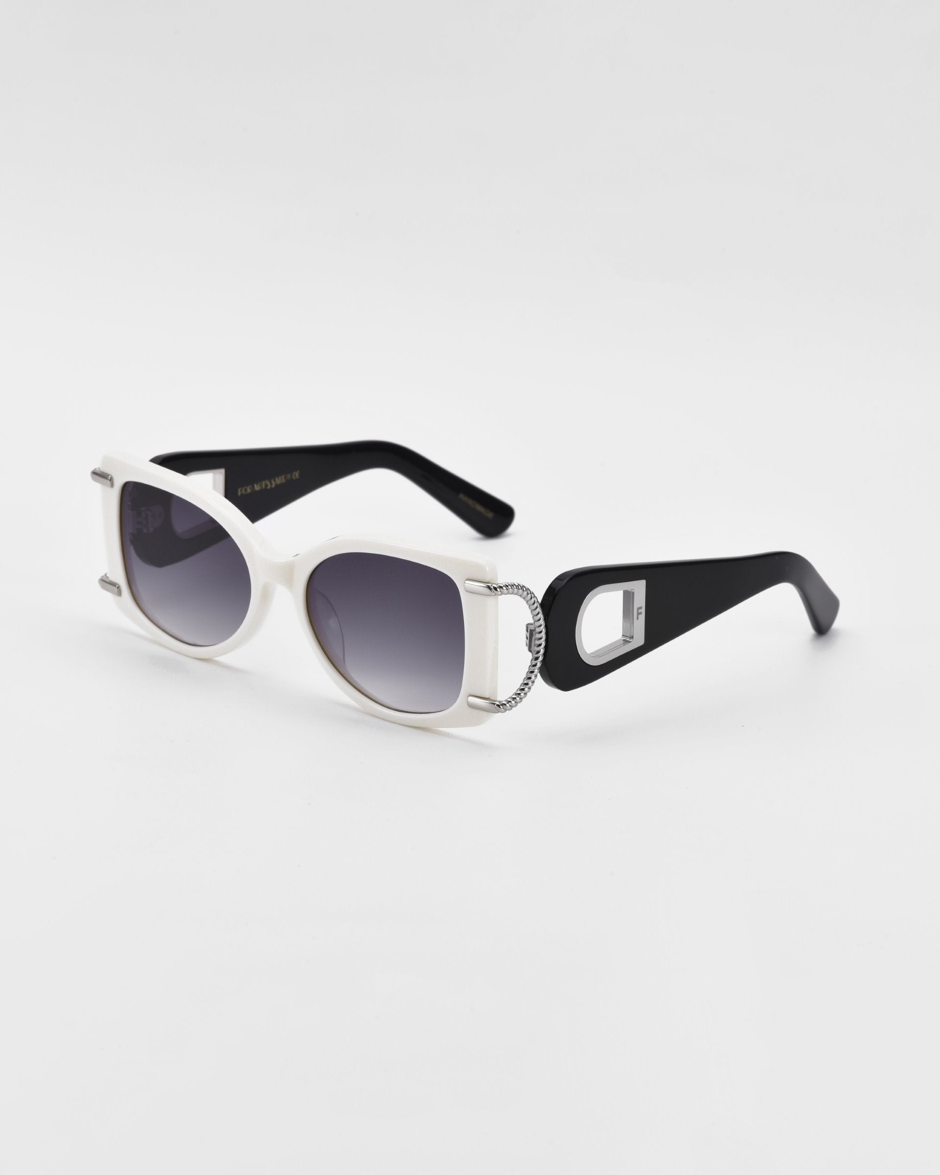 A pair of stylish white acetate For Art&#39;s Sake® Sculpture sunglasses with dark tinted lenses. The thick black temples feature a decorative silver hoop with an 18-karat gold-plated clasp detail at the hinge, providing 100% UVA &amp; UVB protection. The design combines retro and contemporary elements against a plain white background.