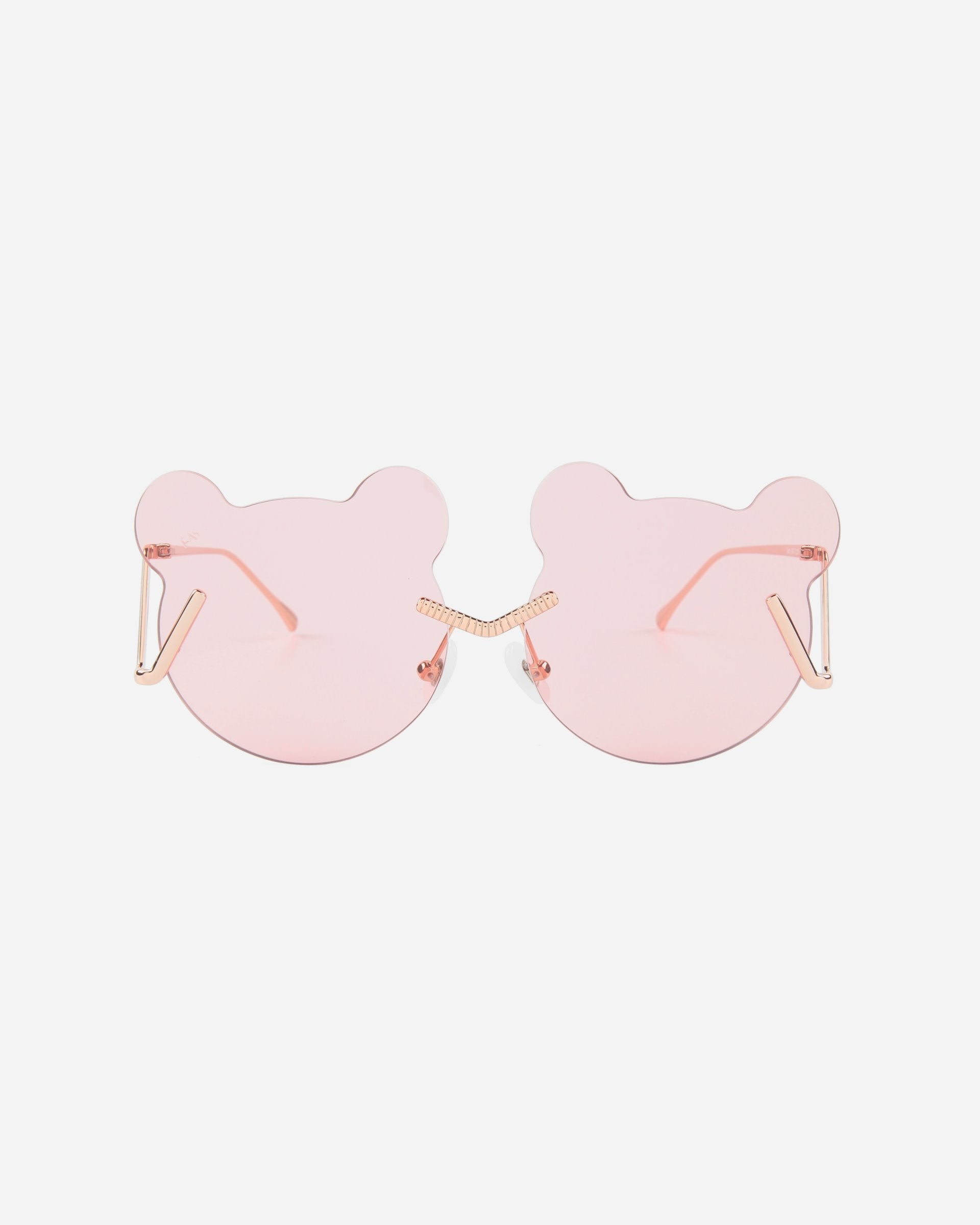 For Art's Sake® Teddy Pink sunglasses are pink, bear-shaped with thin stainless steel arms and no visible frame. The lenses have a light pink tint, offering UV protection, and the nose bridge is designed with small, shiny embellishments. The background is plain white.