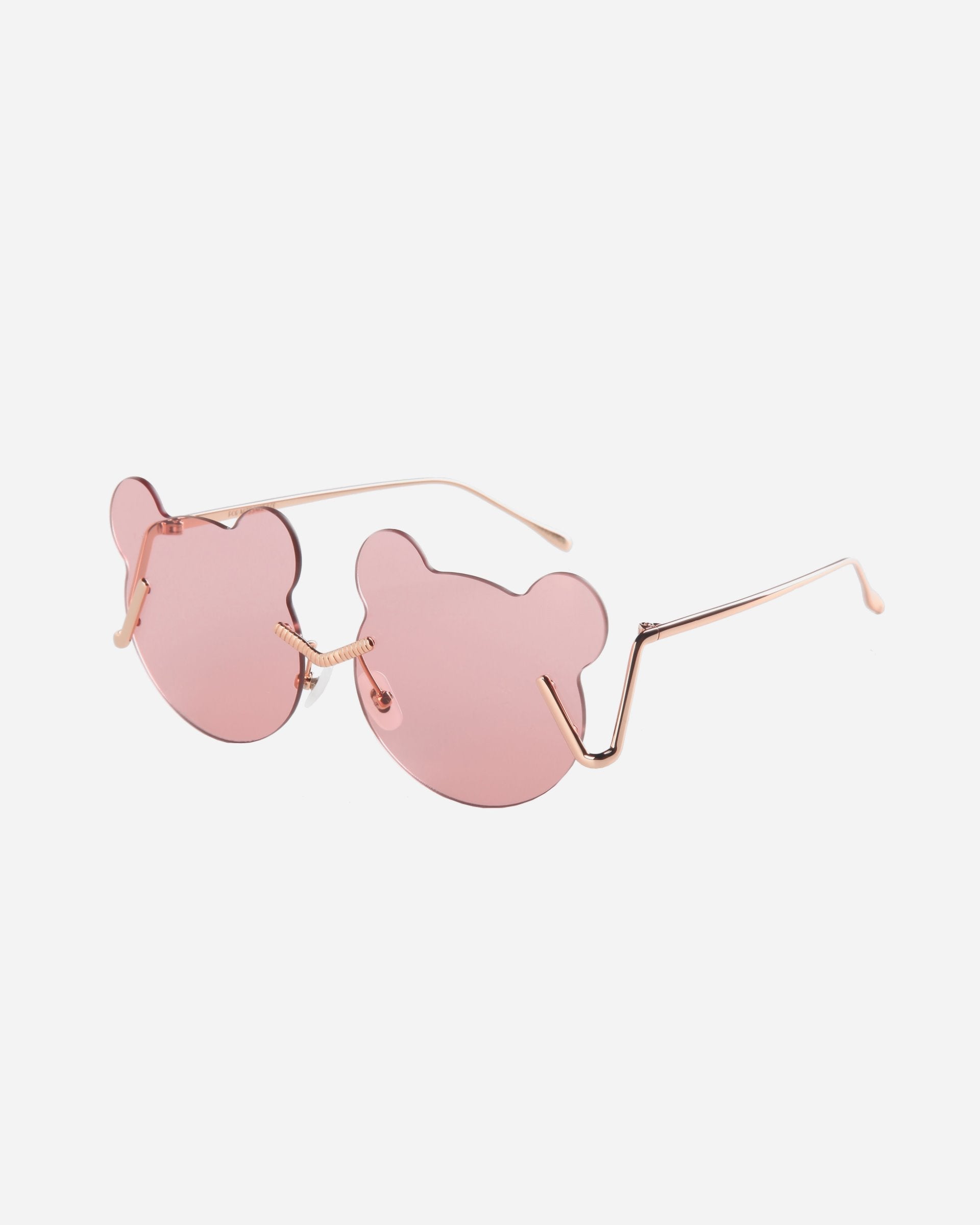 Stylish Teddy Pink sunglasses from For Art&#39;s Sake® with rose-tinted lenses shaped like bear heads and thin gold metal arms, providing ample UV protection against a plain white background.