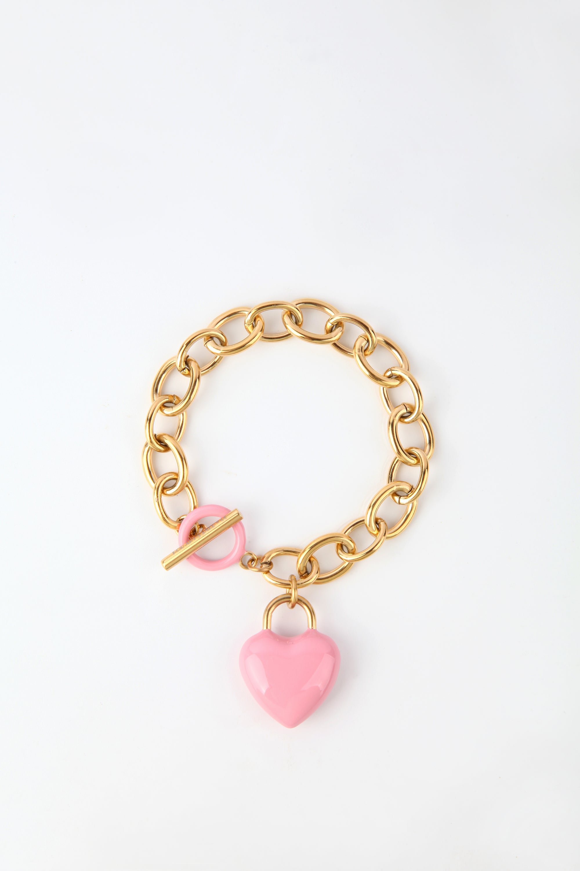 The Kiss Bracelet by For Art's Sake® is crafted with 18k gold, featuring a toggle clasp and an enamel-covered heart charm. The chain boasts large oval links, while the glossy pink heart charm adds a touch of color to the elegant design. Displayed against a plain white background, this piece exudes sophistication.