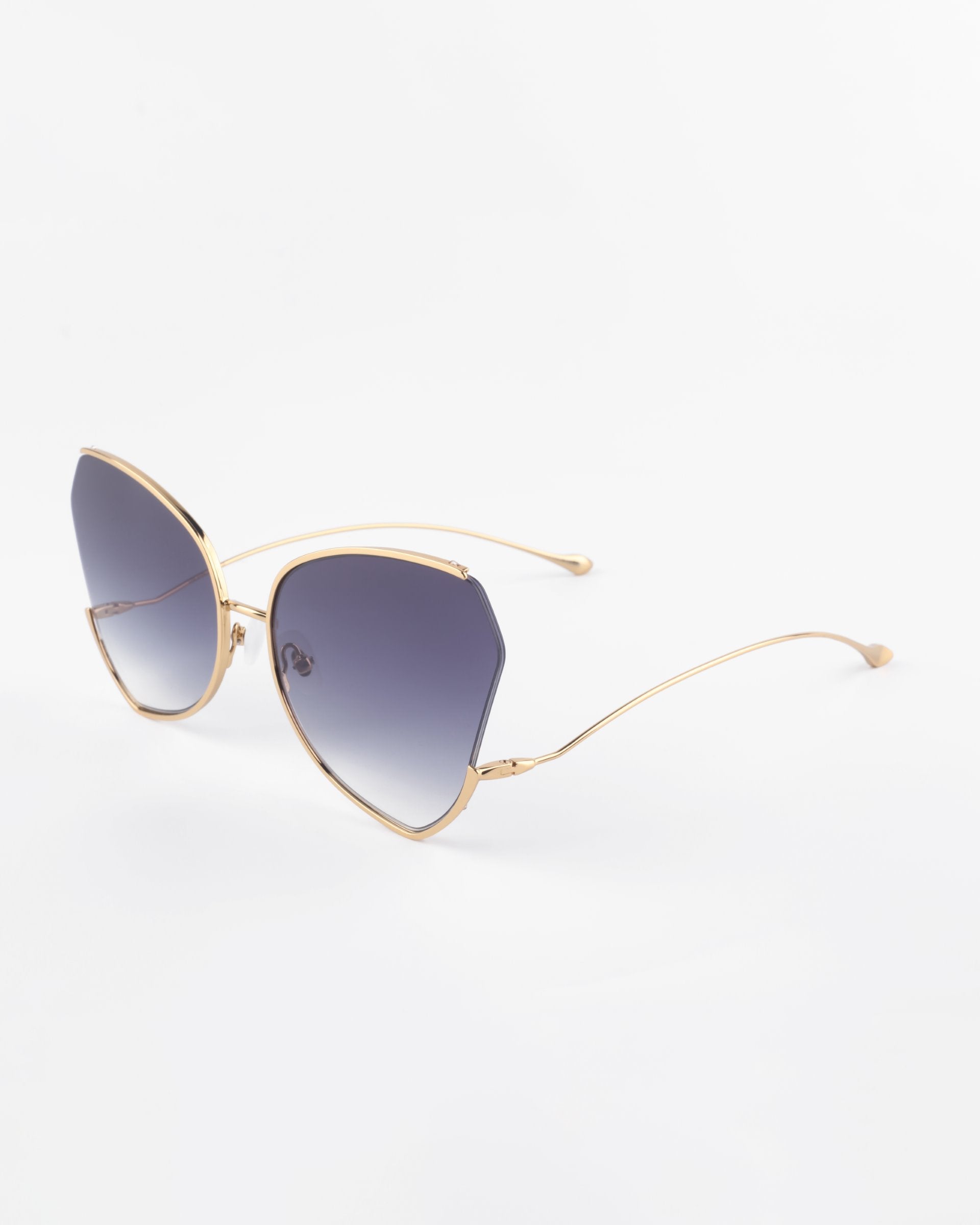 A pair of For Art&#39;s Sake® Watercolour sunglasses with gold-plated stainless steel frames and large, gradient gray ombré lenses. The design features a slight cat-eye shape, creating a fashionable and elegant look against a plain white background.