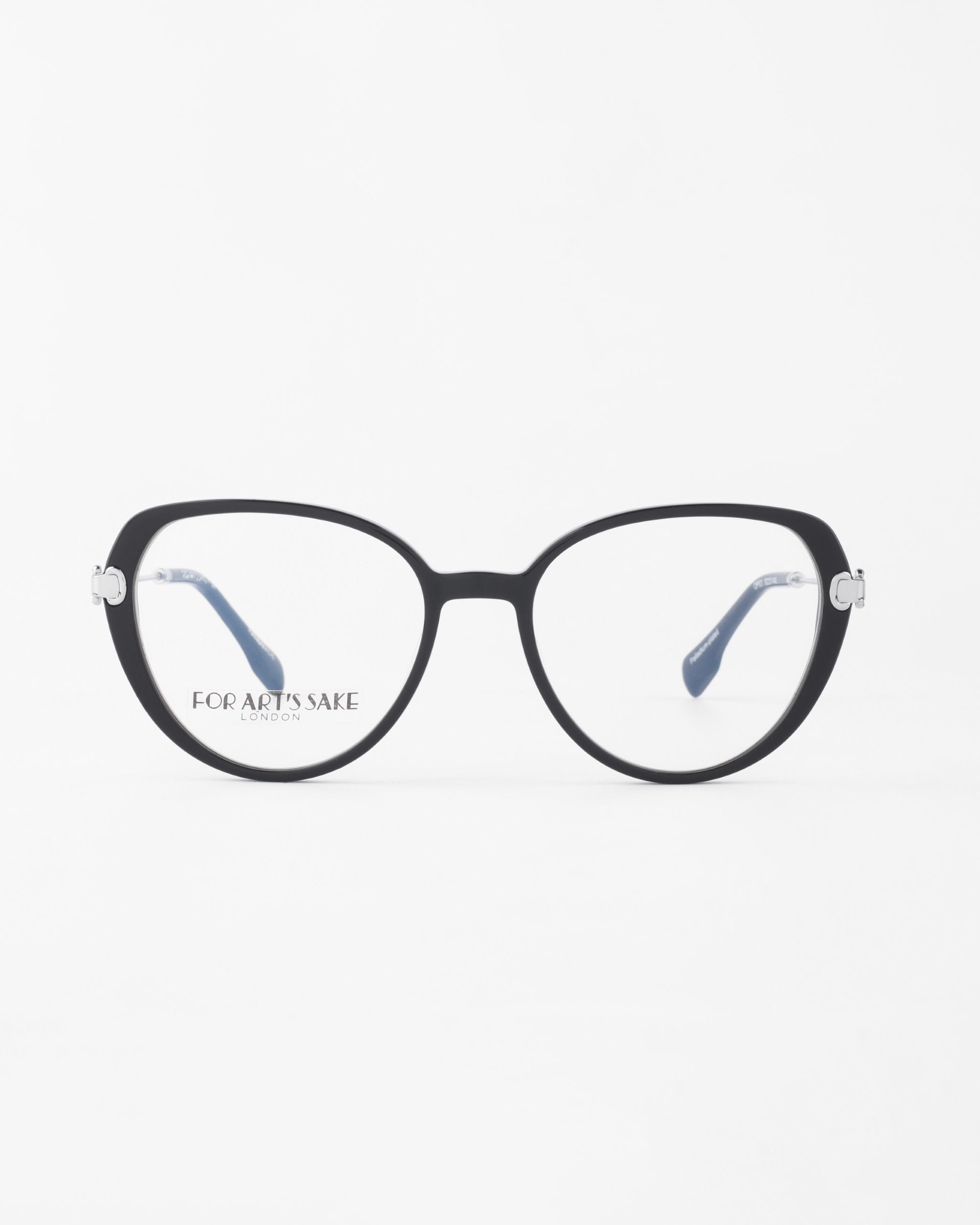 A pair of black-rimmed eyeglasses with a slightly rounded cat-eye shape, featuring the &quot;For Art&#39;s Sake®&quot; logo on the inside of the right lens. The frames have 18-karat gold-plated silver accents at the hinges, and the temples are navy blue with white tips. These eyeglasses are called Waterhouse by For Art&#39;s Sake®.