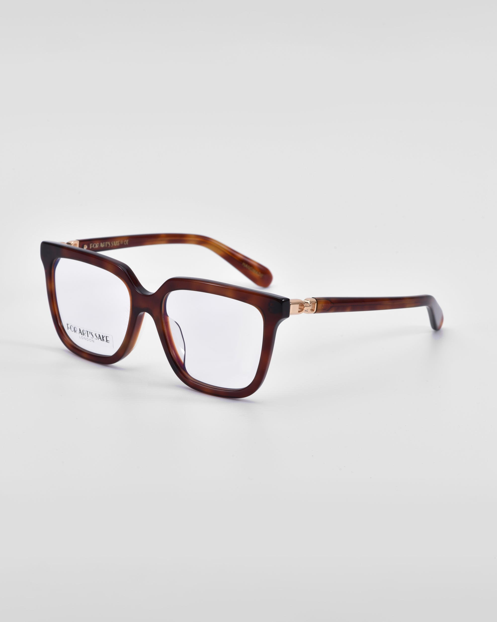 A pair of stylish eyeglasses with a dark tortoiseshell frame and clear lenses. The temples have a subtle 18-karat gold detail near the hinges. Featuring a classic square silhouette, the brand name &quot;For Art&#39;s Sake®&quot; is visible on the inside of the left temple.