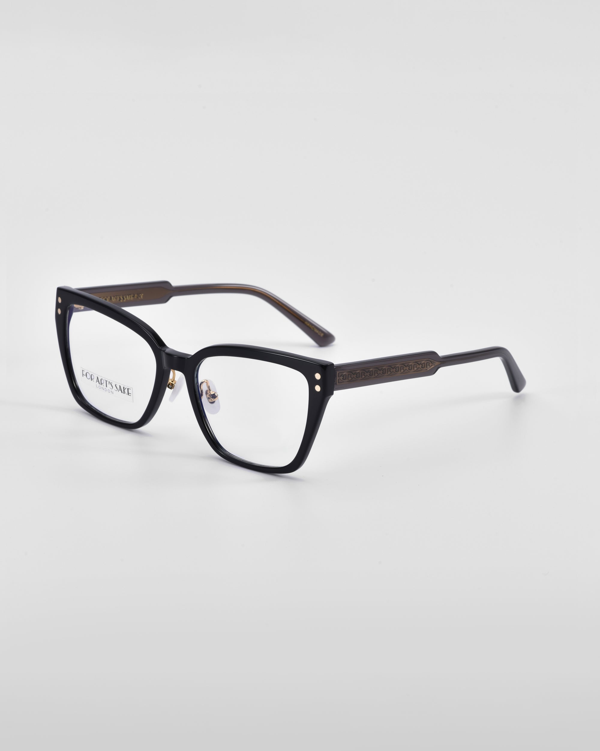 A pair of black rectangular eyeglasses with subtle link-chain pattern detailing on the temples. The glasses have clear lenses and a simple, modern design suitable for both casual and formal wear. The background is a plain, light grey. These are the Abbey eyeglasses by For Art's Sake®.
