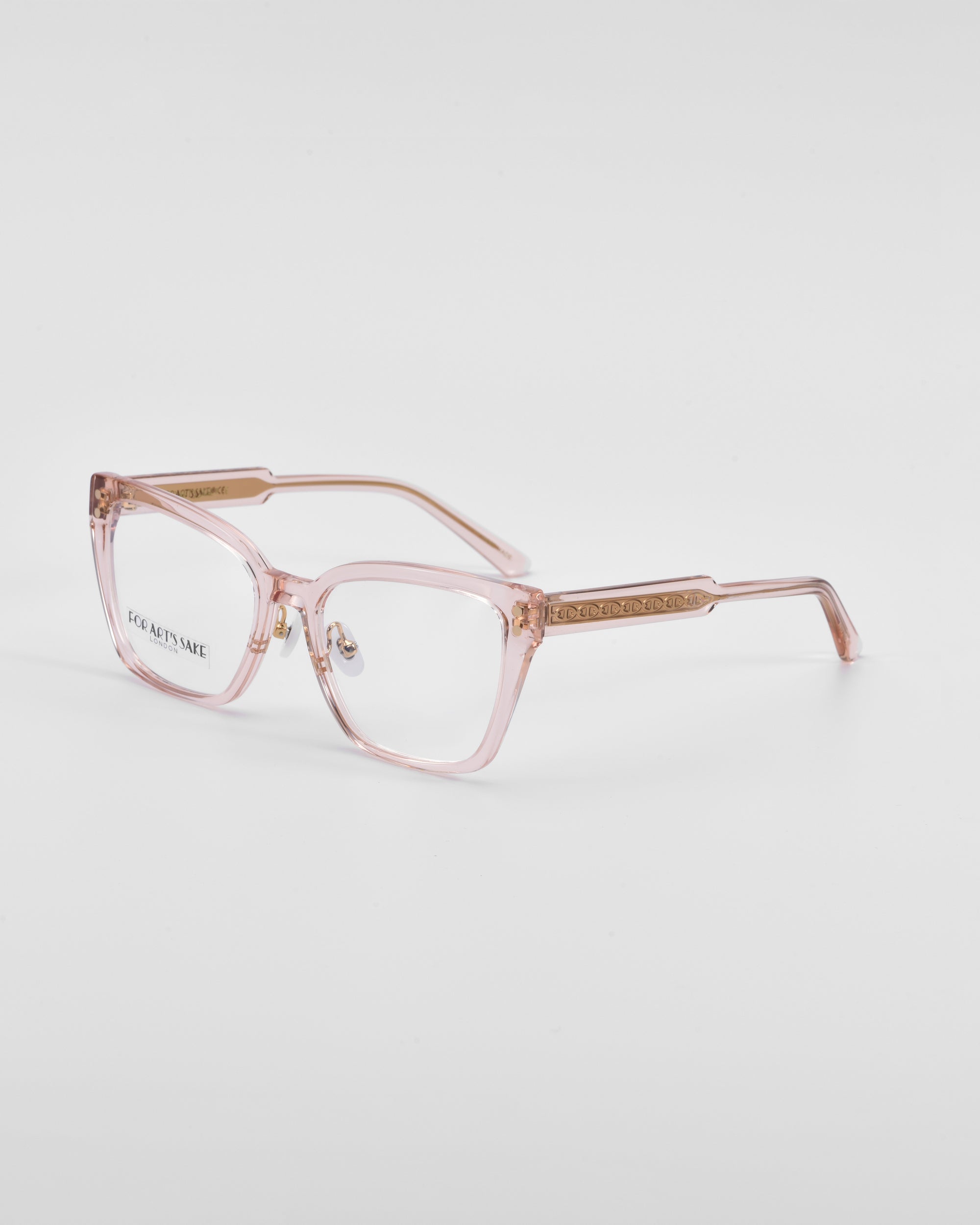 A pair of transparent pink Abbey glasses by For Art&#39;s Sake® with subtle golden accents on the temples, which feature a delicate link-chain pattern etched into them. The Abbey glasses boast rectangular lenses and a slightly oversized frame design. The background is white.