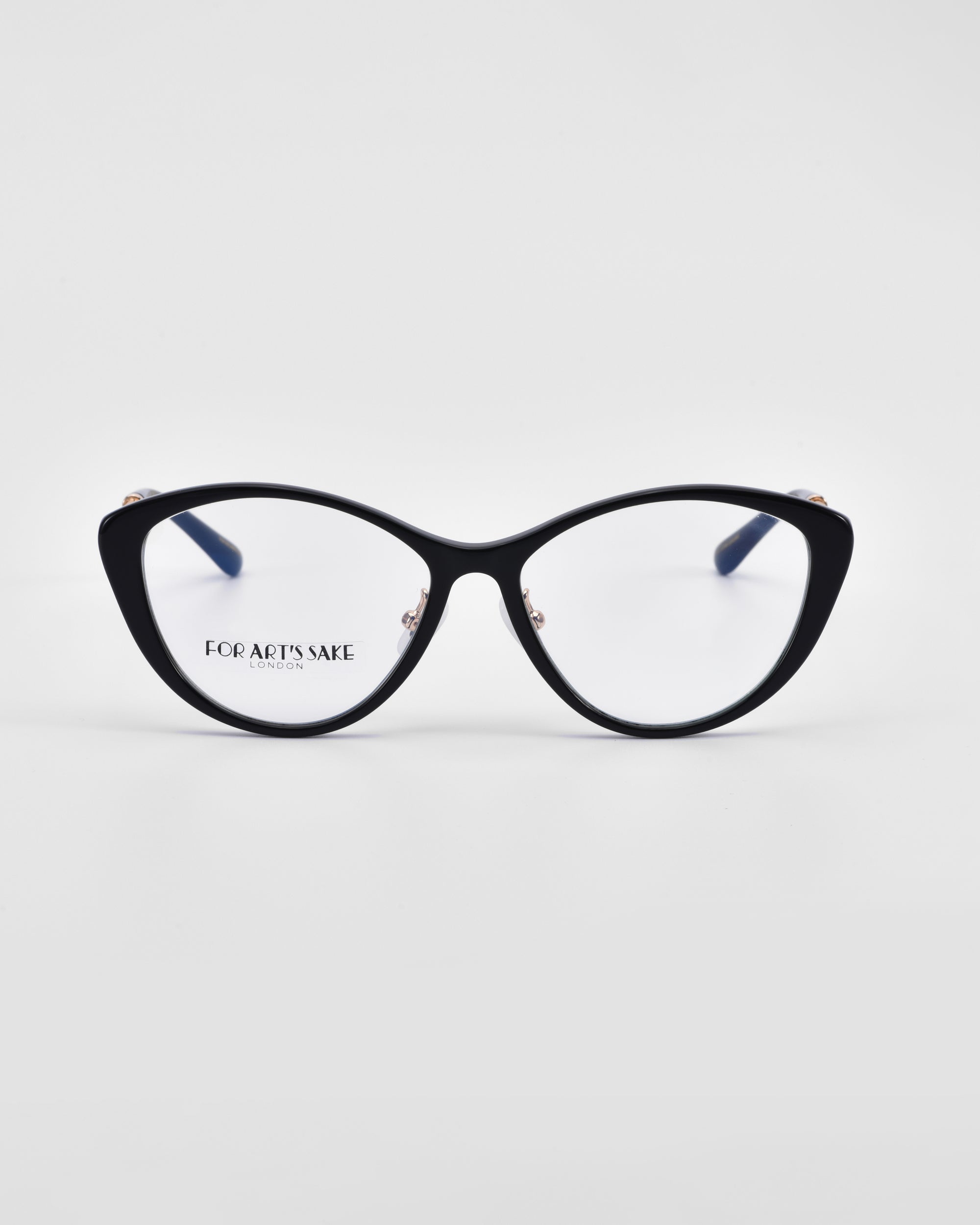 A pair of black cat-eye glasses with clear lenses is shown against a white background. The glasses feature jade-stone nose pads and an 18-karat gold plating, boasting a sleek and modern design with &quot;For Art&#39;s Sake®&quot; branding visible on the inside of one lens.