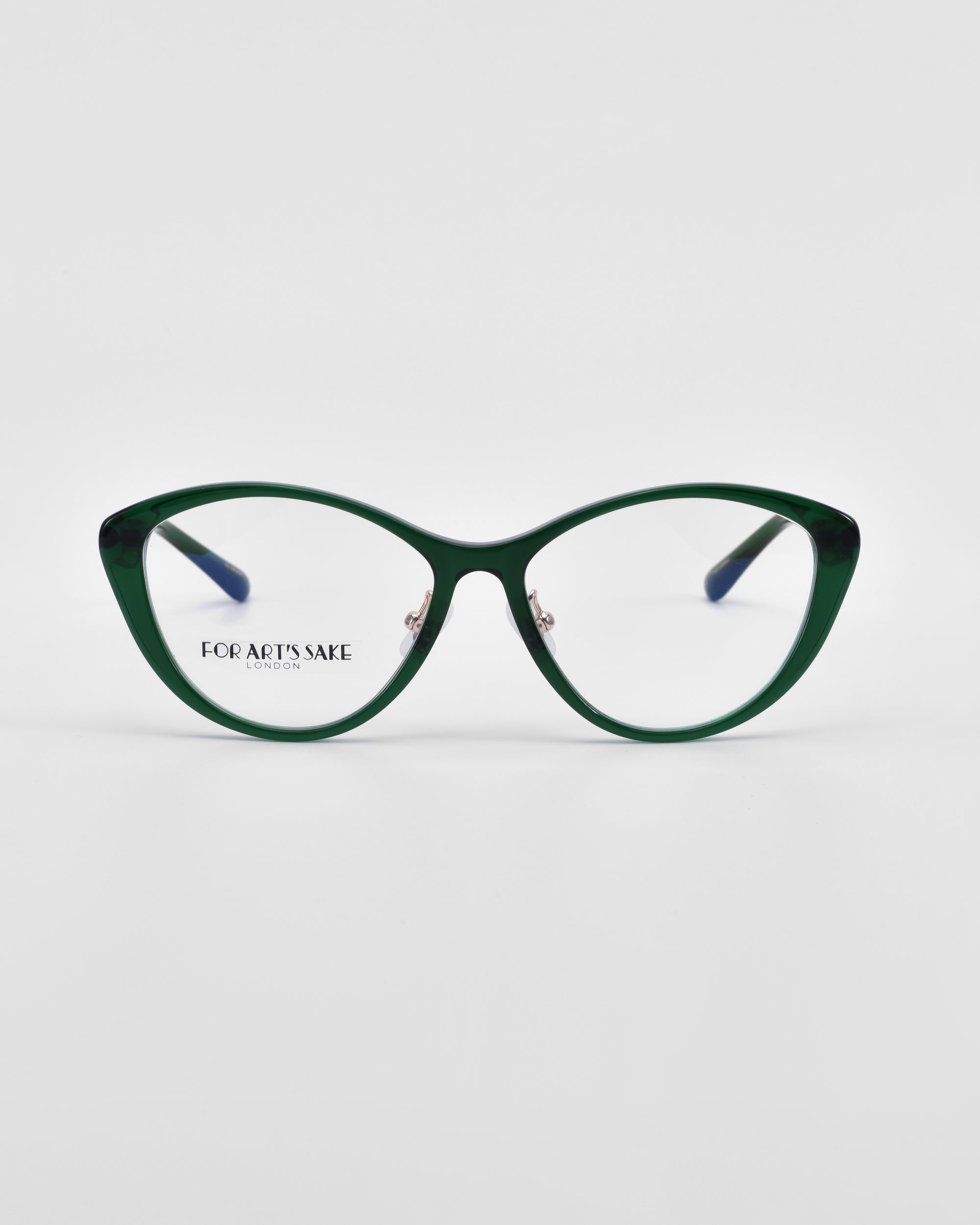 A pair of stylish green cat-eye eyeglasses with blue temples and jade-stone nose pads. The lenses are clear, and the words &quot;For Art&#39;s Sake®&quot; are printed on the left lens. These Perla II eyeglasses boast an optical design finesse and are set against a plain white background.