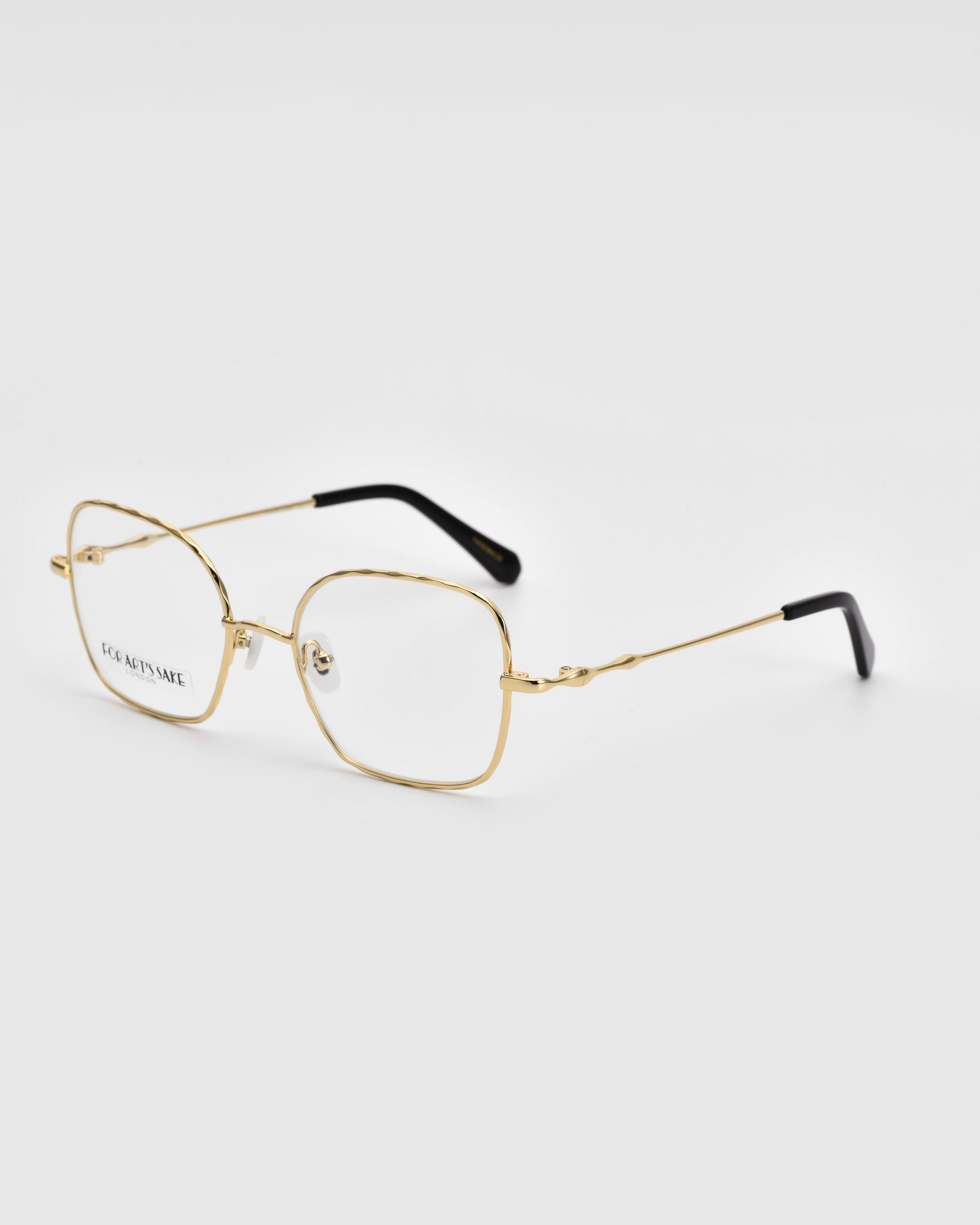 A pair of Bone II by For Art&#39;s Sake® with thin, gold metallic wireframe construction and rectangular lenses are shown against a plain white background. The temples have black tips for added comfort.