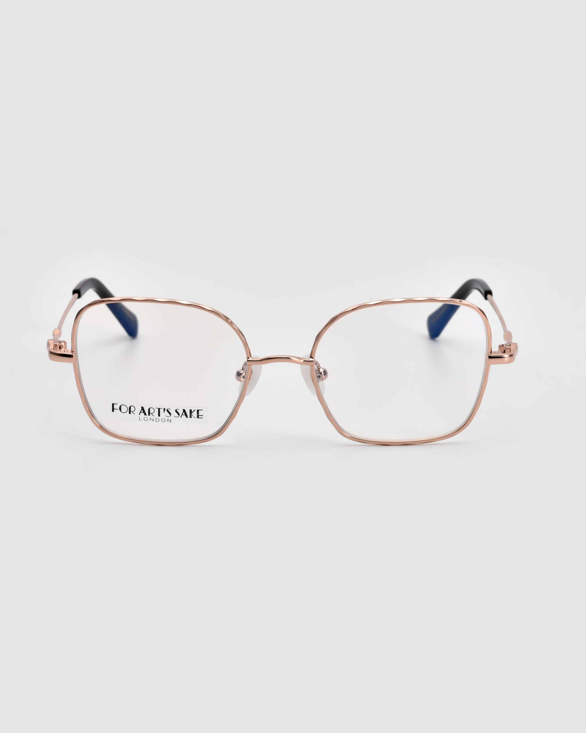 Front view of the Bone II eyeglasses from For Art's Sake®, featuring clear lenses, a thin rose gold metal frame with slightly rounded edges, and wireframe construction. The glossy black temple tips boast a unique, curved shape. The brand name "Bone II" is visible on the left lens. The background is plain white.