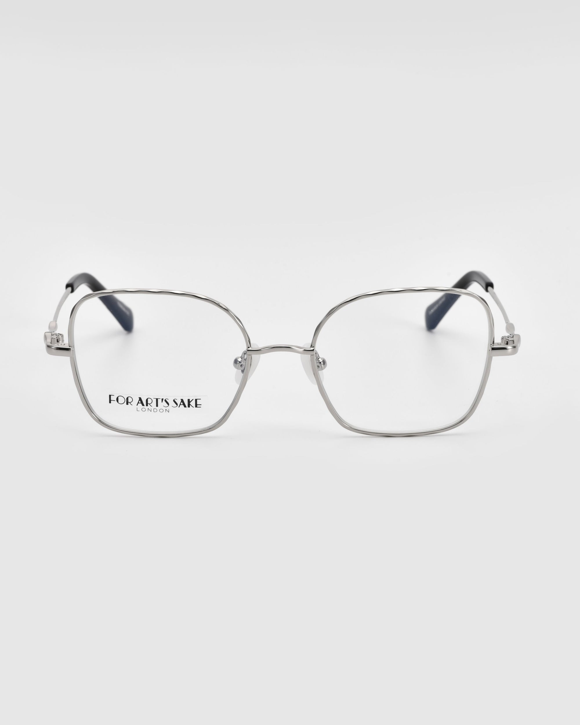 A pair of Bone II by For Art's Sake® silver-framed eyeglasses with a slightly rounded rectangular shape is displayed against a plain white background. The brand name "For Art's Sake" is visible on the left lens. The temples have a contrasting dark color, showcasing meticulous wireframe construction.