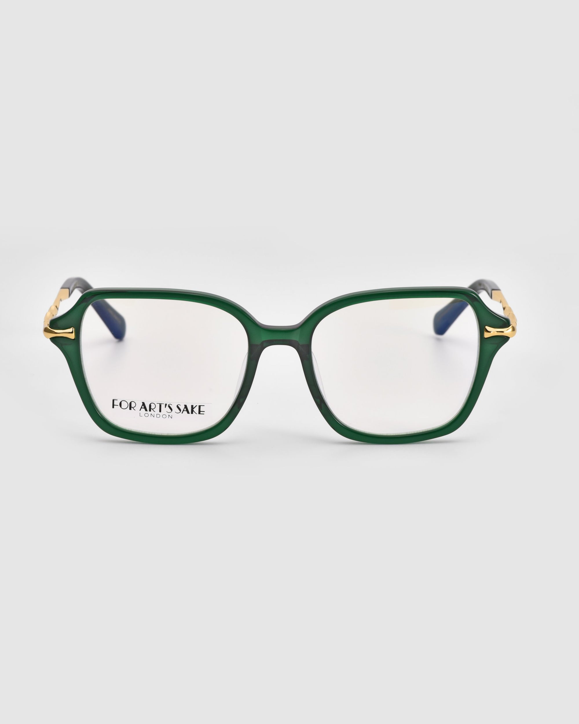 A pair of Delight rectangular green eyeglasses with gold detailing on the upper corners of the frames evoke a vintage charm infused with modern sophistication. The glasses sit against a plain white background, and the inside of the left lens displays the text "For Art's Sake® London.