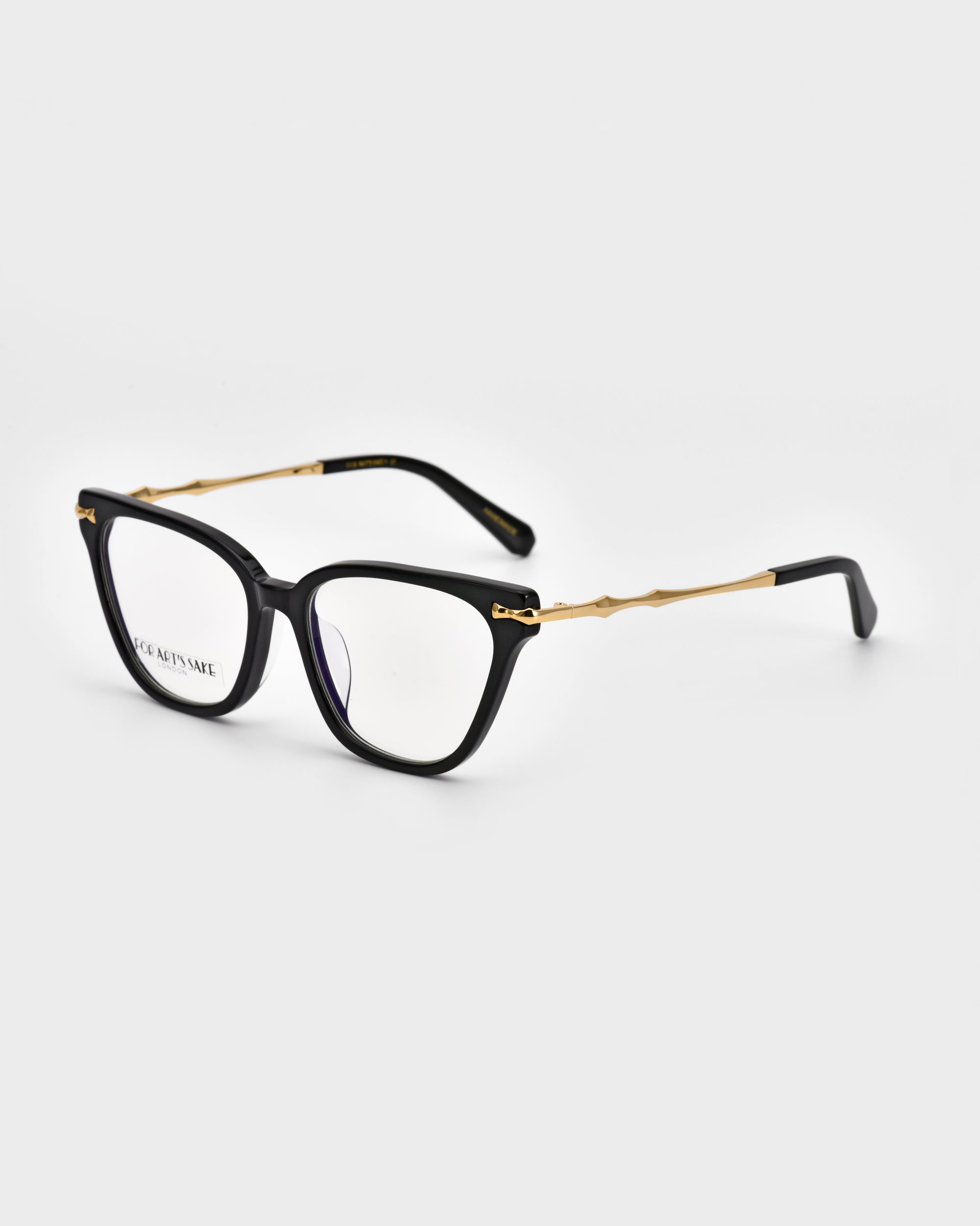 A pair of black rectangular eyeglasses from For Art's Sake®'s Lexie collection is displayed against a white background. The design features gold accents on the temples and clear lenses, with one lens showcasing a small printed text detail from Lexie Opticals, giving it a sleek and chic aesthetic.