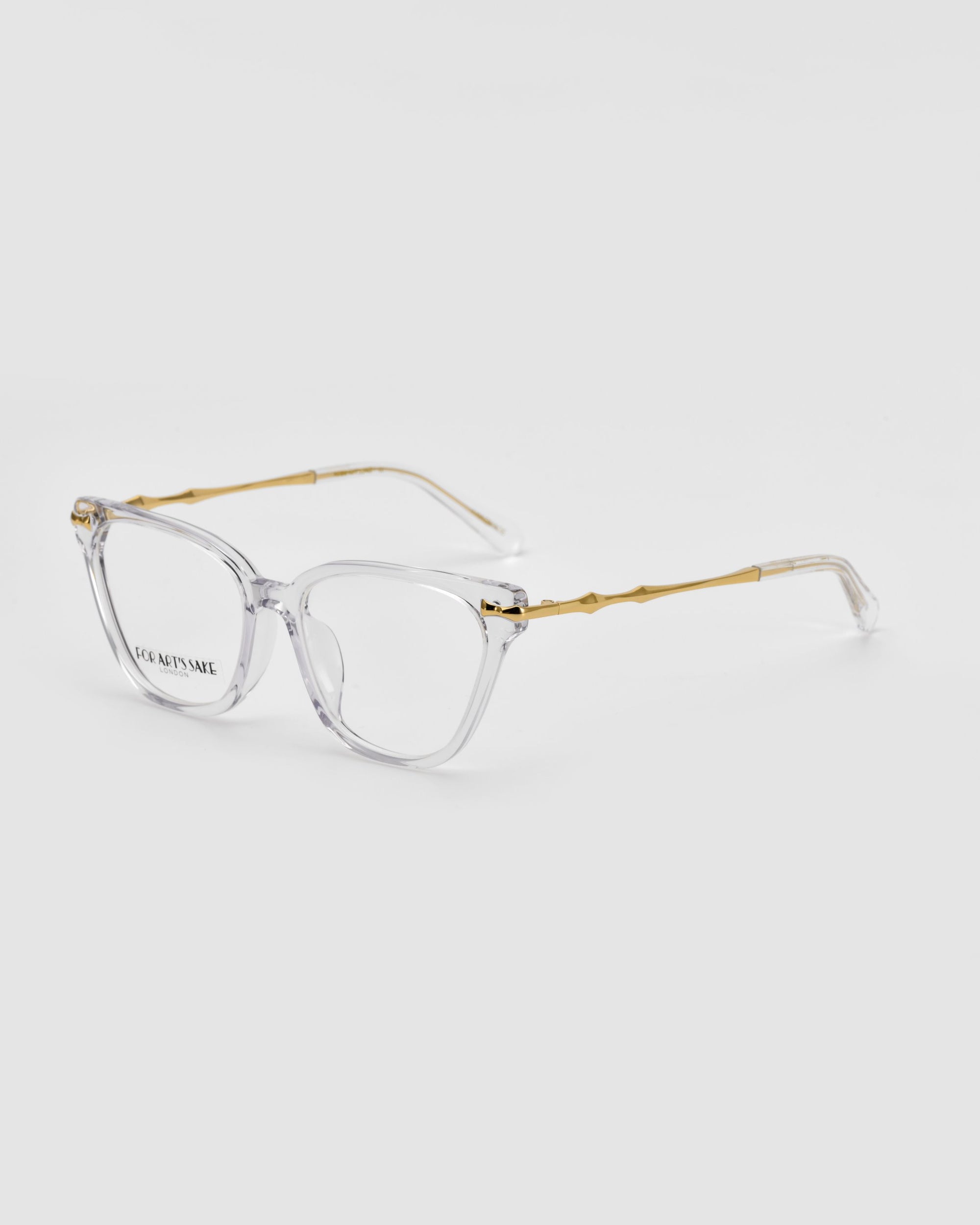 A pair of stylish eyeglasses with clear rectangular frames and gold-colored temples. The temples feature a subtle bamboo pattern. The brand's name "For Art's Sake®" is visible on one lens, elegantly showcasing the Lexie craftsmanship. The glasses are set against a plain white background.