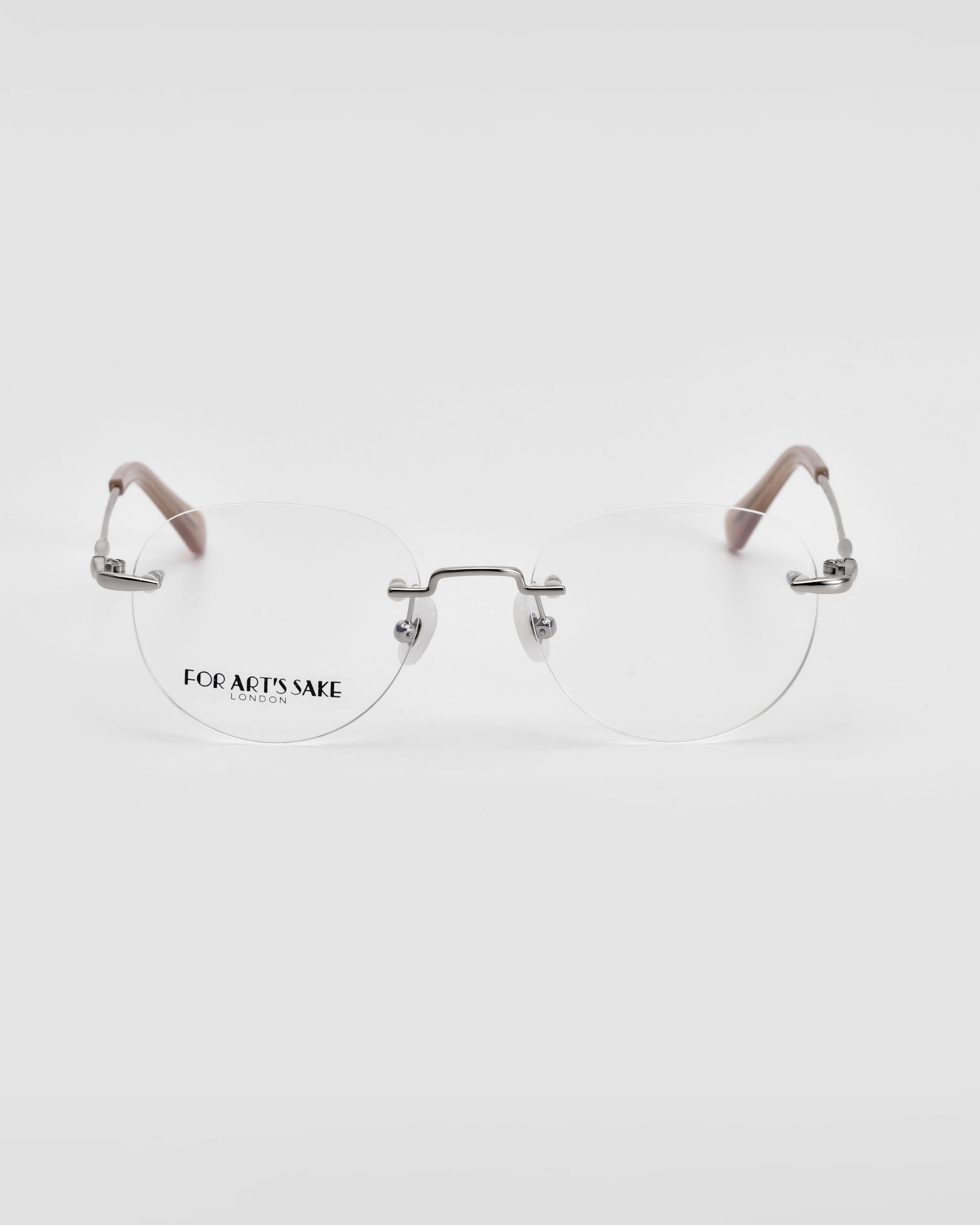 A pair of Misty rimless eyeglasses with silver-toned metal detailing and beige temple tips, featuring wireframe construction. The brand name &quot;For Art&#39;s Sake®&quot; is visible on the left lens against a white background.