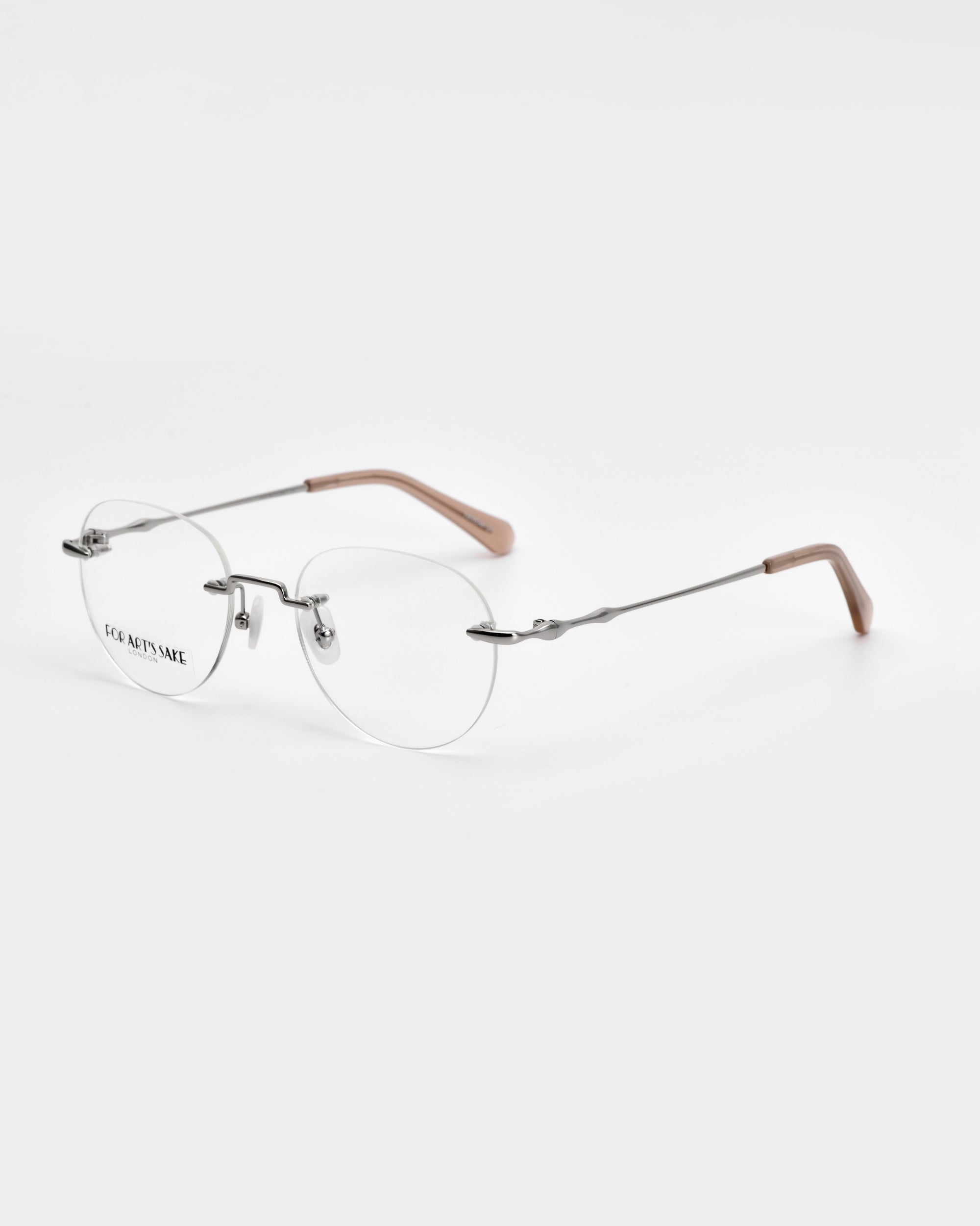 The Misty, a pair of minimalist, round-lensed rimless eyeglasses by For Art&#39;s Sake®, features thin silver metal temples with brown plastic tips. With clear lenses and a slightly curved bridge, the glasses’ wireframe construction is elegantly displayed against a plain white background.