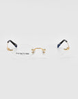 A pair of sleek, rimless Zesty eyeglasses with thin, gold-colored temples and nose bridge from For Art's Sake®. The tips of the temples are black. The lightweight optical glasses rest on a white background and have "FOR ART'S SAKE LONDON" printed on the left lens.