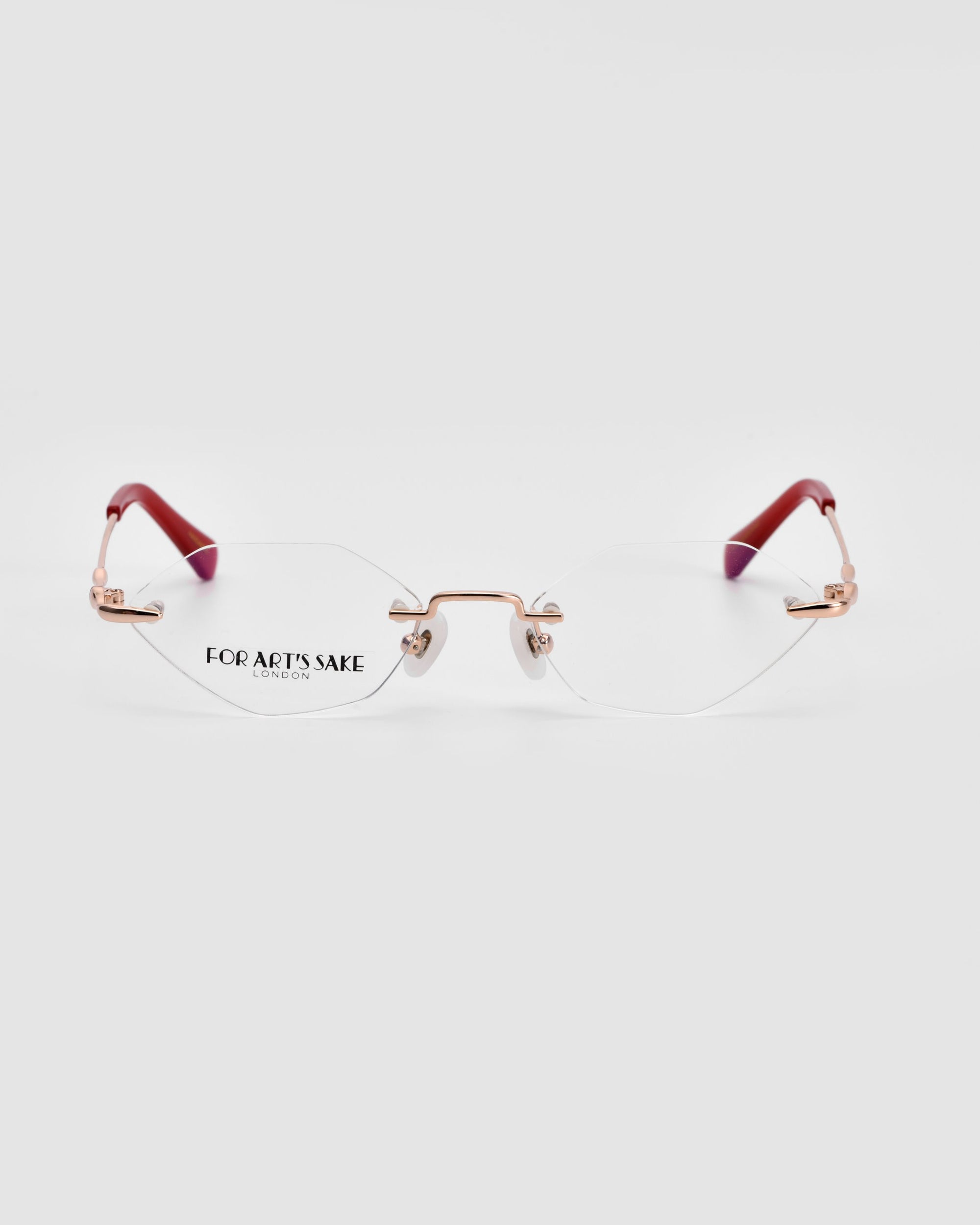 A pair of Zesty eyewear by For Art's Sake®, featuring lightweight rectangular lenses, a gold-colored bridge and hinges, and red-tipped temple arms. The left lens is marked with "FOR ARTS SAKE." The modern minimalism design of these glasses stands out against a plain white background.