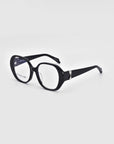 The Bow glasses from For Art's Sake® are showcased against a white backdrop, featuring bold and stylish oversized black rectangular lenses. The thick frames and temples, made from biodegradable acetate, are adorned with a decorative silver accent near the hinges.