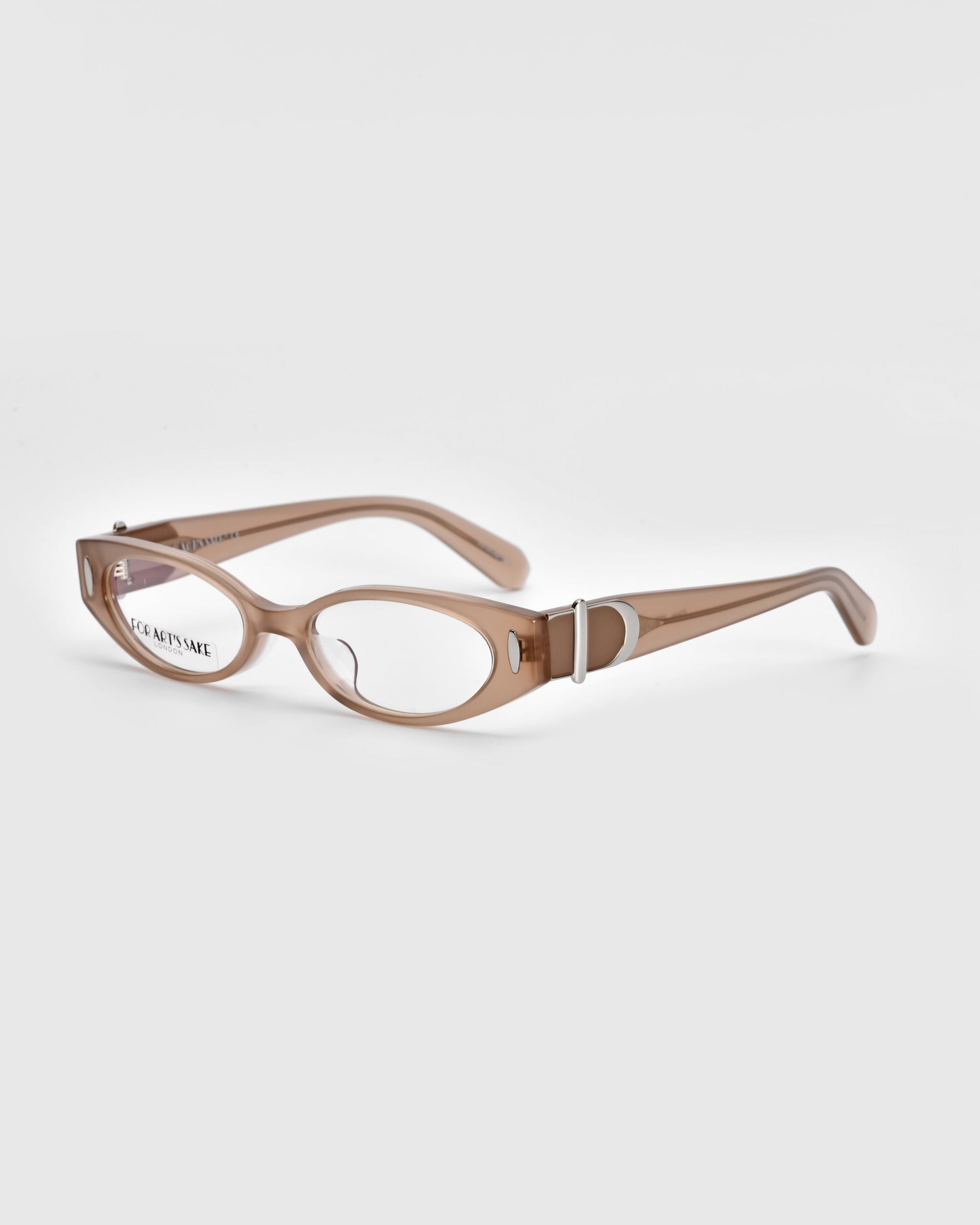 A pair of beige-colored reading glasses with a sleek, oval frame design exudes vintage charm. The inside of the right earpiece is inscribed with text. Crafted with polished acetate temples, these For Art&#39;s Sake® Cigar frames are placed on a white background, completing the refined look.