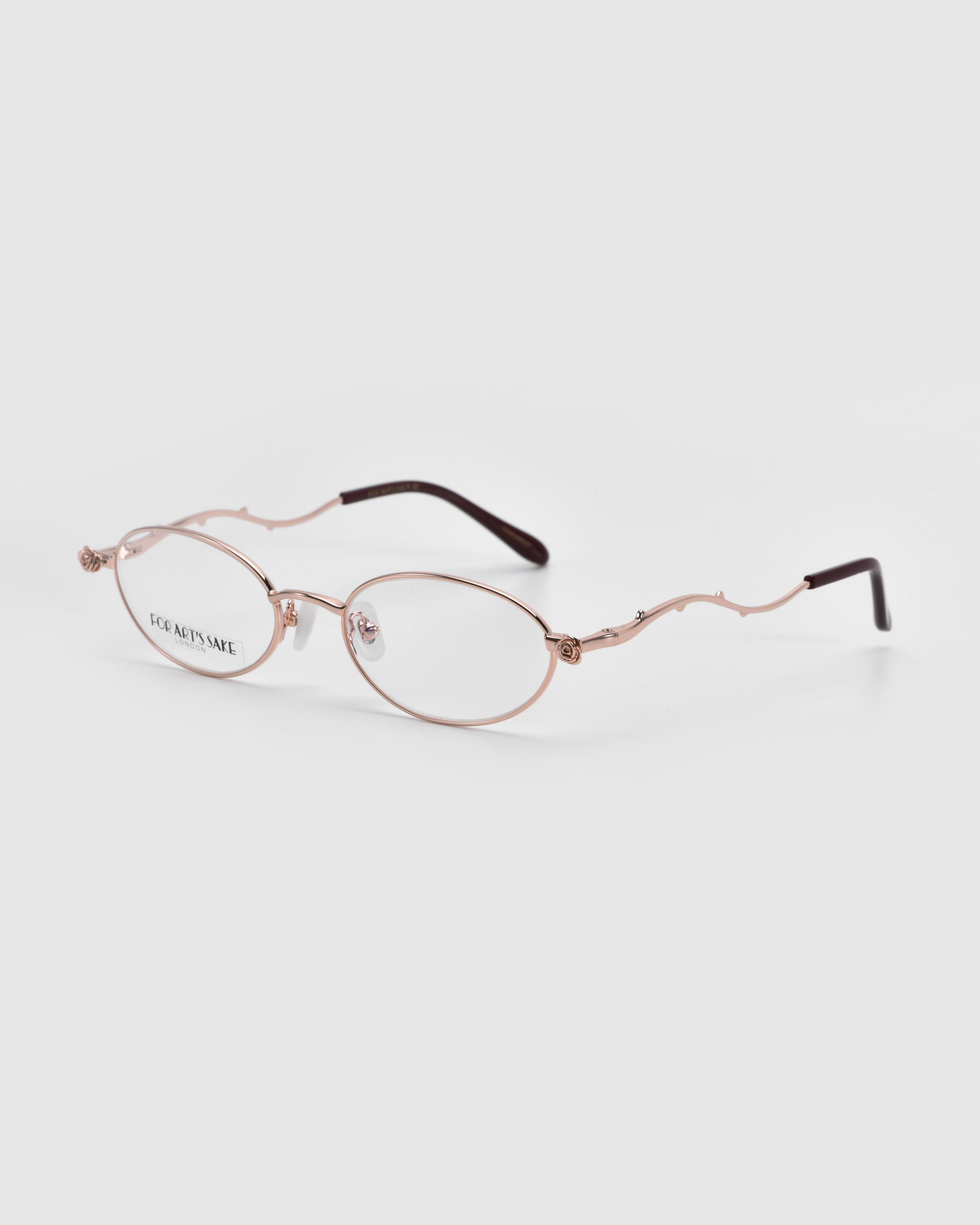 The Thorn by For Art's Sake® are elegant optical glasses featuring a thin, metallic wavy frame with oval lenses and subtly curved temple arms. They offer a sophisticated, artistic expression against a plain white background.