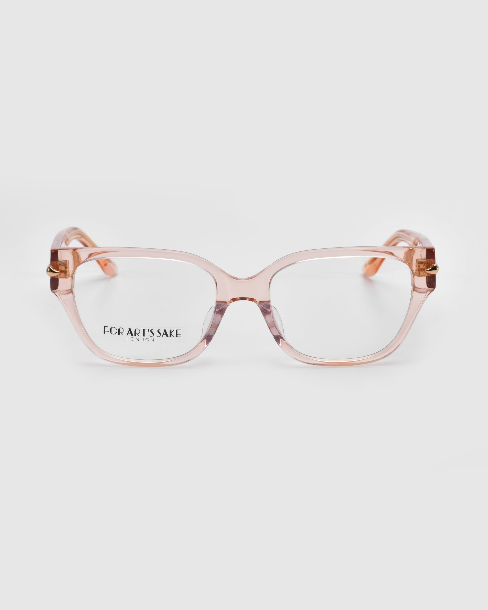 The Eros eyeglasses from For Art's Sake® feature a stylish transparent peach-colored cat-eye acetate frame. The subtly tinted arms have a gold accent near the hinges, and the brand is visible on the left lens.