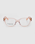 The Eros eyeglasses from For Art's Sake® feature a stylish transparent peach-colored cat-eye acetate frame. The subtly tinted arms have a gold accent near the hinges, and the brand is visible on the left lens.