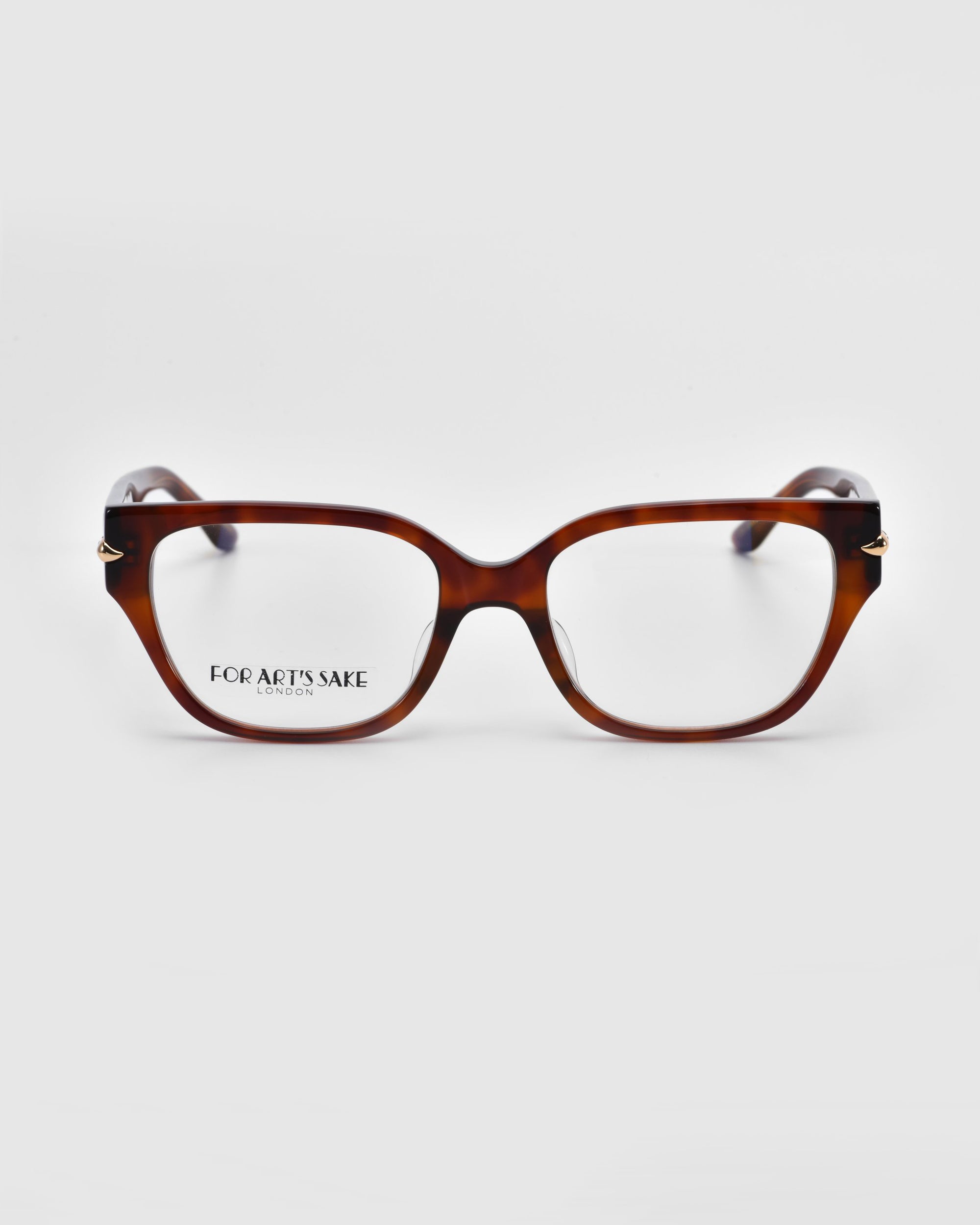 The Eros glasses by For Art's Sake® feature chic brown tortoiseshell rectangular frames with clear lenses, elegantly resting on a white background. The brand name graces the left lens, offering the sophistication and versatility of everyday sunglasses.