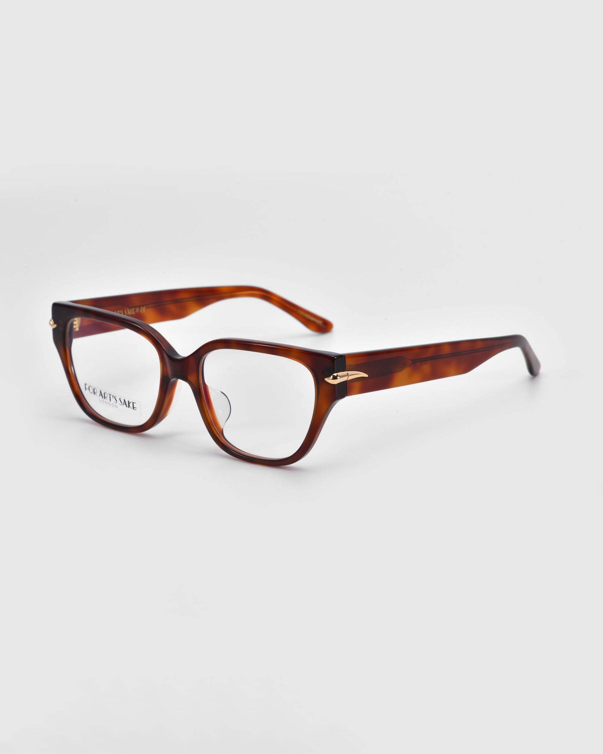 The Eros eyeglasses by For Art's Sake® feature a tortoiseshell design with rectangular frames and clear lenses. Part of the Rose Garden collection, they lie diagonally on a white background, showcasing an elegant charm with slightly open arms.