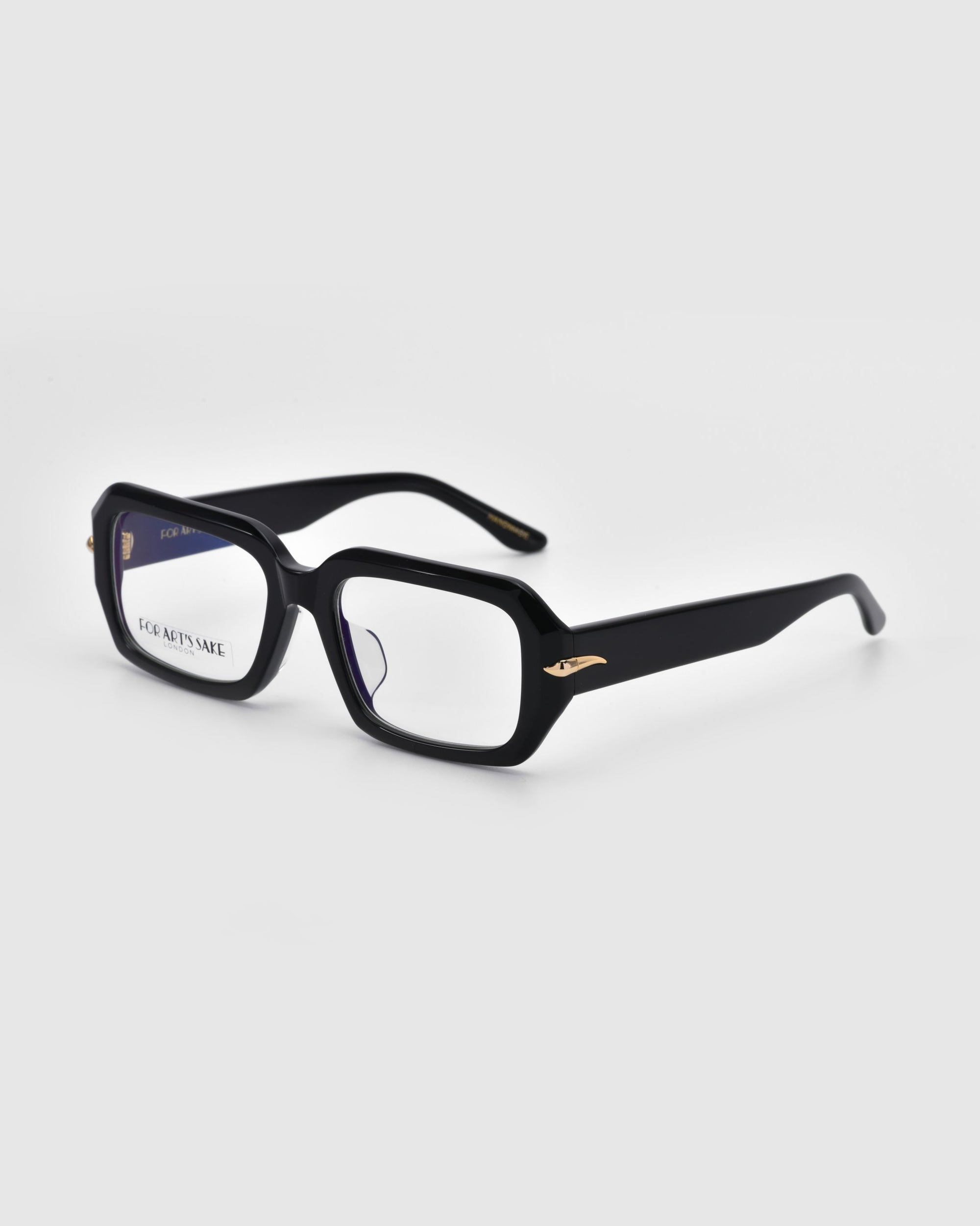 The For Art's Sake® Petal eyeglasses feature black rectangular frames with thick acetate and slightly curved arms. Clear lenses are set in the frames, with a small gold accent near each hinge, resting elegantly against a pure white background.