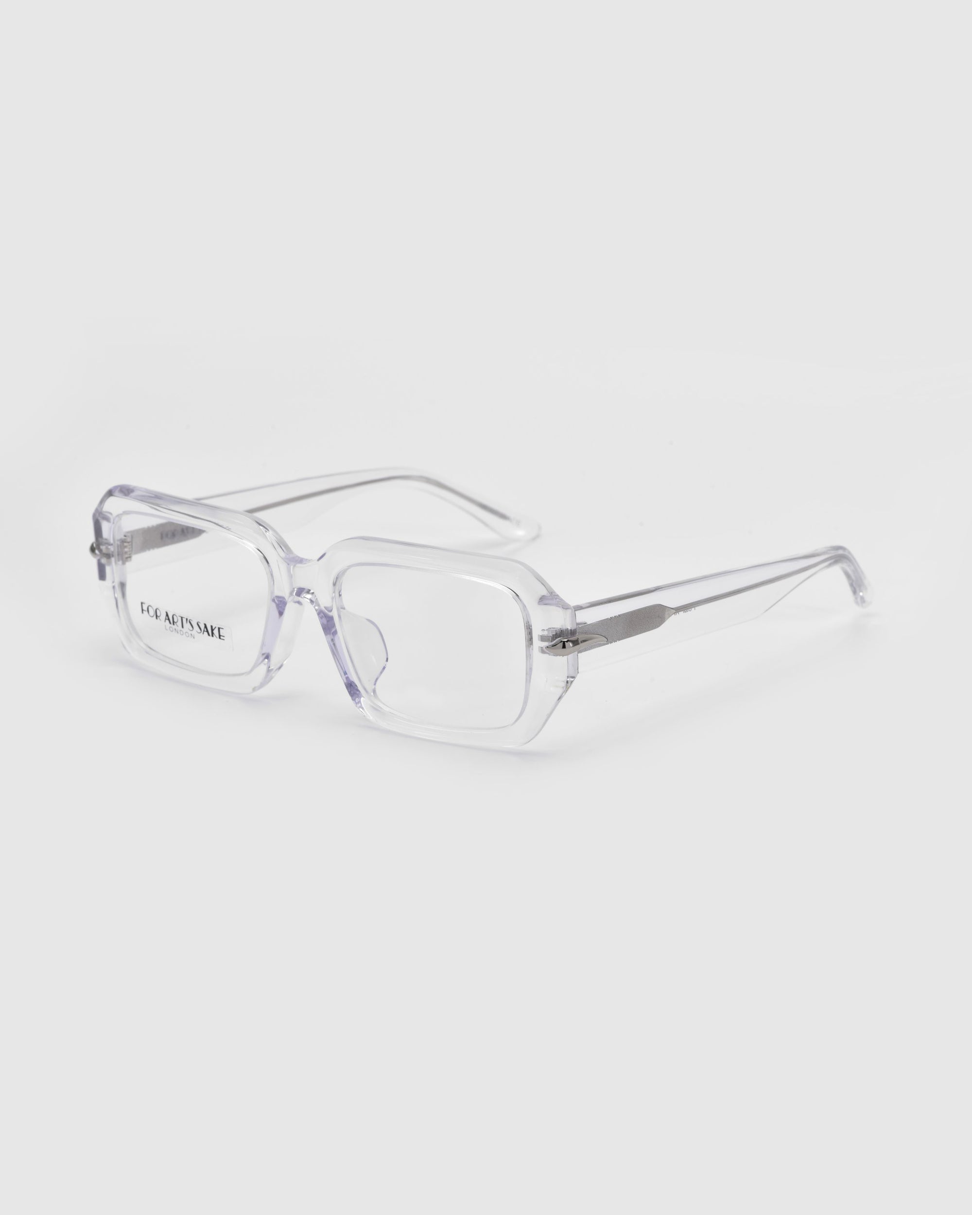 The Petal eyeglasses from For Art&#39;s Sake® are showcased on a white background, featuring a clear rectangular design with a chunky acetate frame. This transparent style offers simple, modern elegance, ideal for subtly enhancing your look.