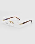 Part of the Rose Garden collection, the "Hampton" rimless glasses from For Art's Sake® feature hexagonal lenses with gold detailing and dark brown arms. They are showcased on a clean, light gray background that highlights their sophisticated design.