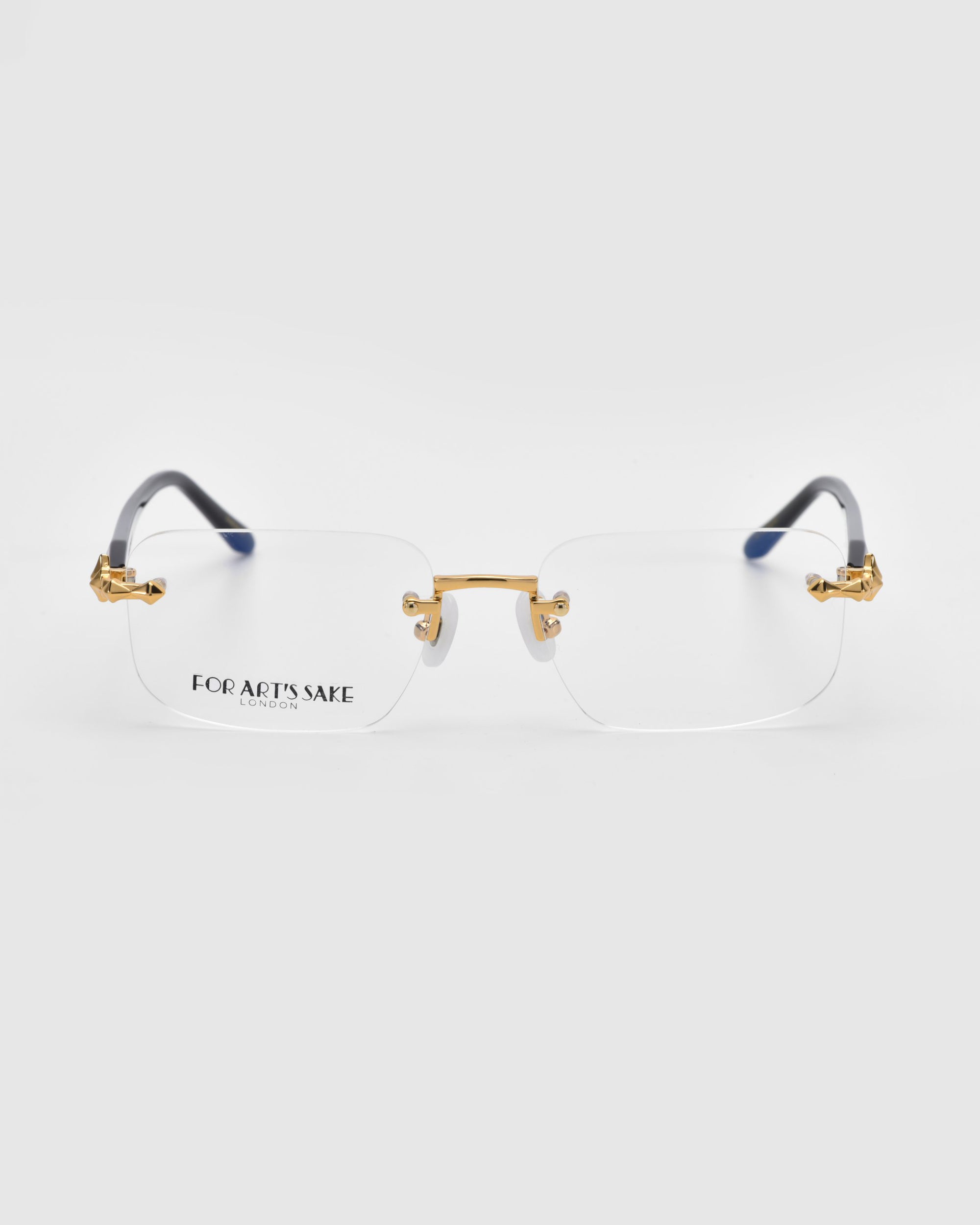 From the Rose Garden collection, the Claremont rimless eyeglasses by For Art's Sake® feature rectangular lenses with gold accents and black temples on a light background, with "For Art's Sake" elegantly displayed on the left lens.