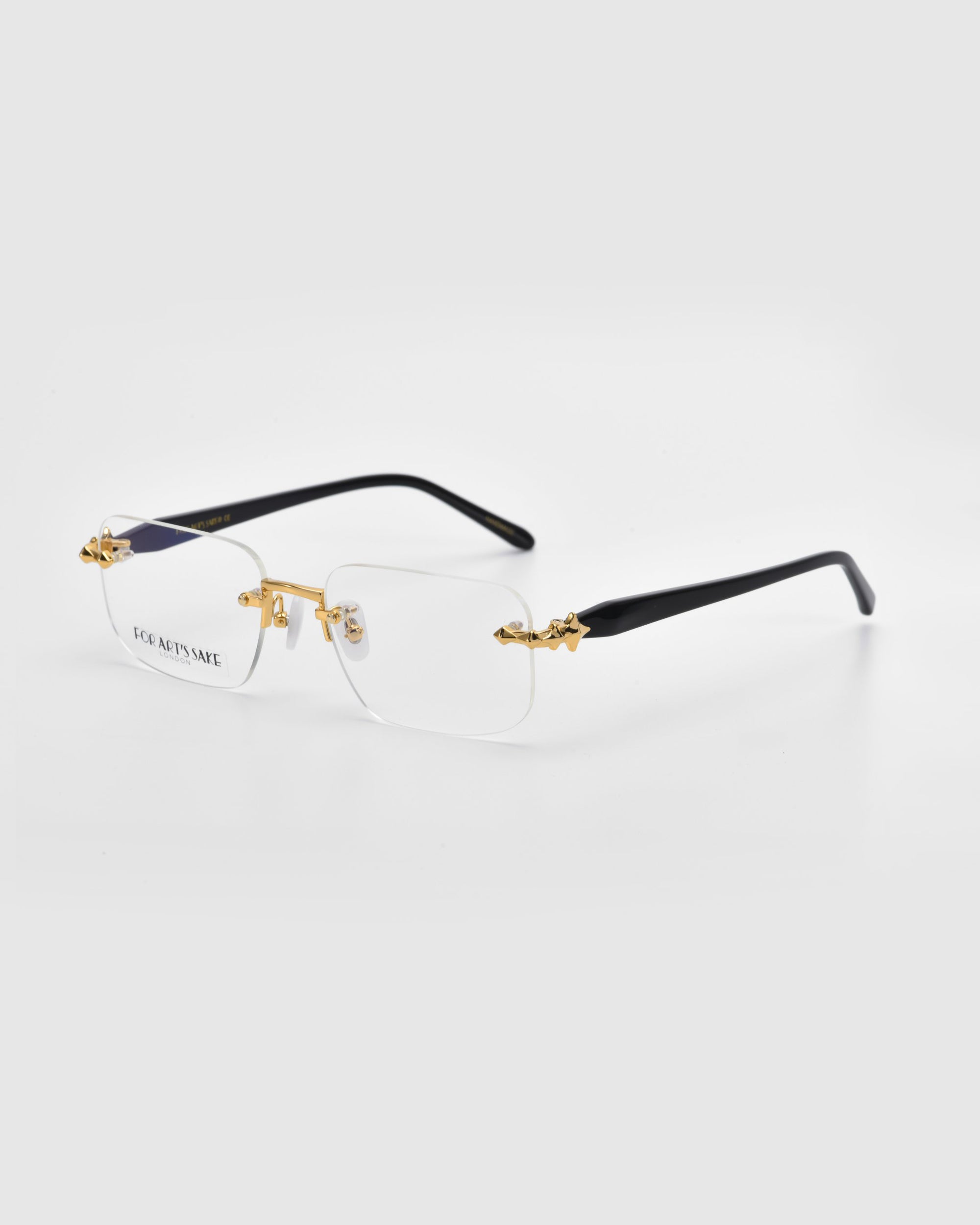 Rimless Claremont eyeglasses by For Art's Sake® feature rectangular lenses with gold detailing and a logo inscription on the left lens, displayed against a plain light background.