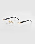 Rimless Claremont eyeglasses by For Art's Sake® feature rectangular lenses with gold detailing and a logo inscription on the left lens, displayed against a plain light background.