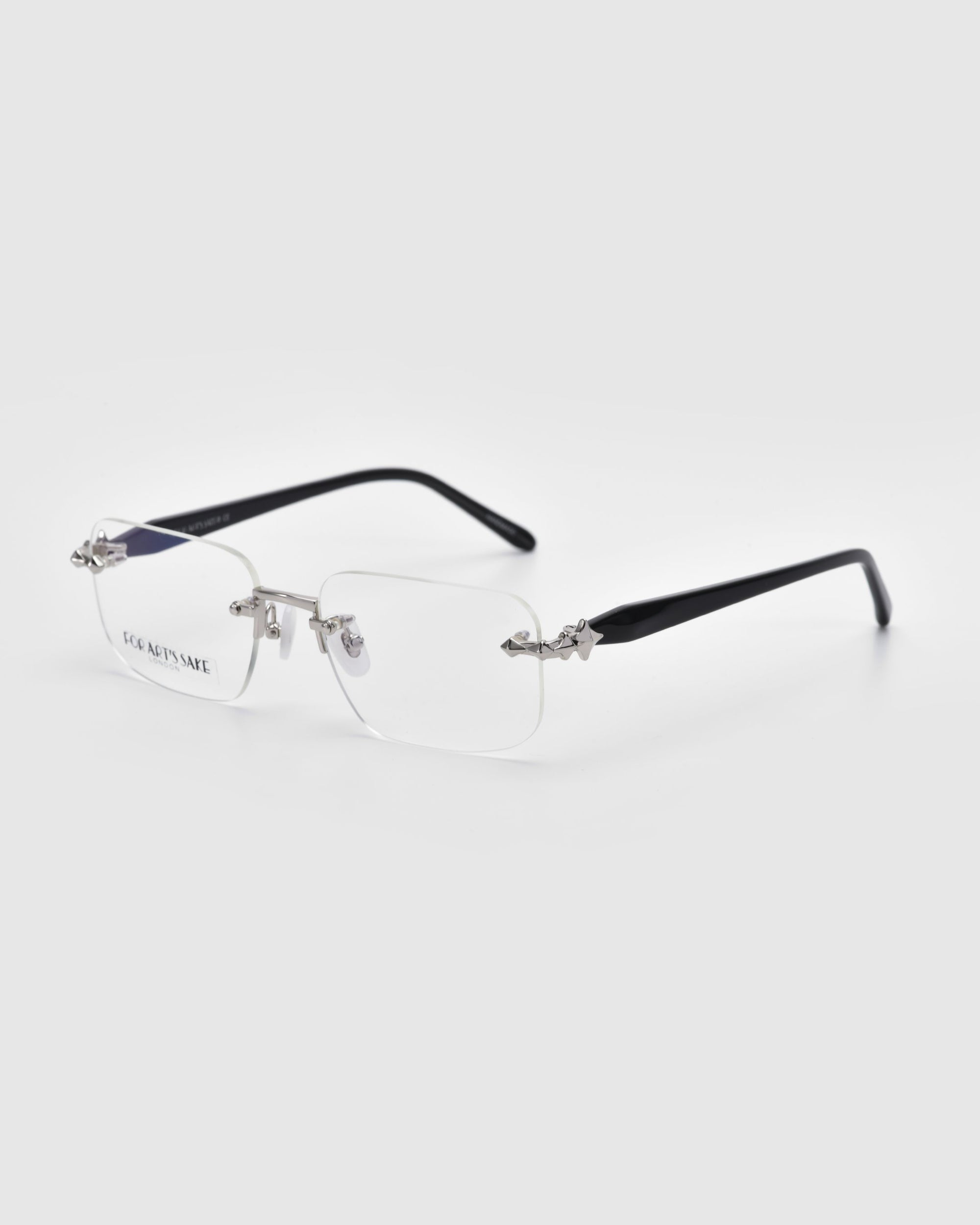 From For Art's Sake® Claremont collection, these rimless eyeglasses feature rectangular clear lenses, thin black temples, and silver accents against a white backdrop, highlighting the elegant design.