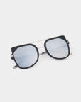 A pair of stylish aviator-style For Art's Sake® Big Game sunglasses with reflective light blue lenses and black square frames. Featuring a double bridge design and metal temples with black tips, these sunglasses also offer UV protection. They are displayed on a light, neutral background.