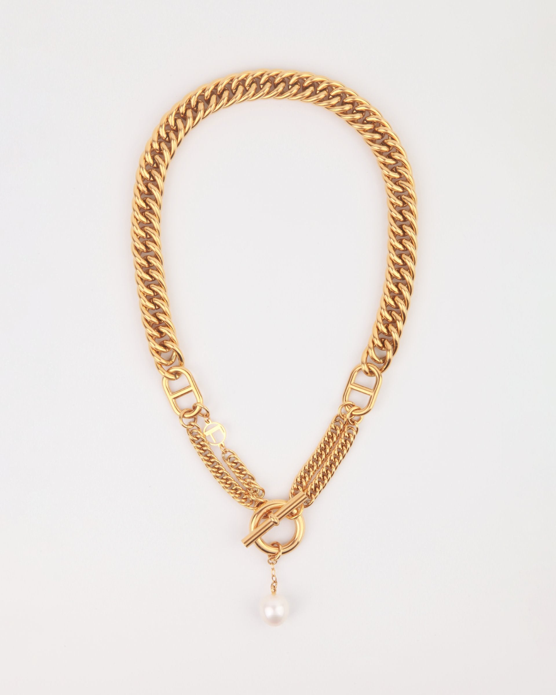 A Girlfriend Necklace by For Art&#39;s Sake®, featuring a gold-plated stainless steel necklace with a toggle clasp and a single freshwater pearl charm hanging from the center. The chunky flat-curb chain features interlocking links and a stylish, elegant design. The background is plain and white.