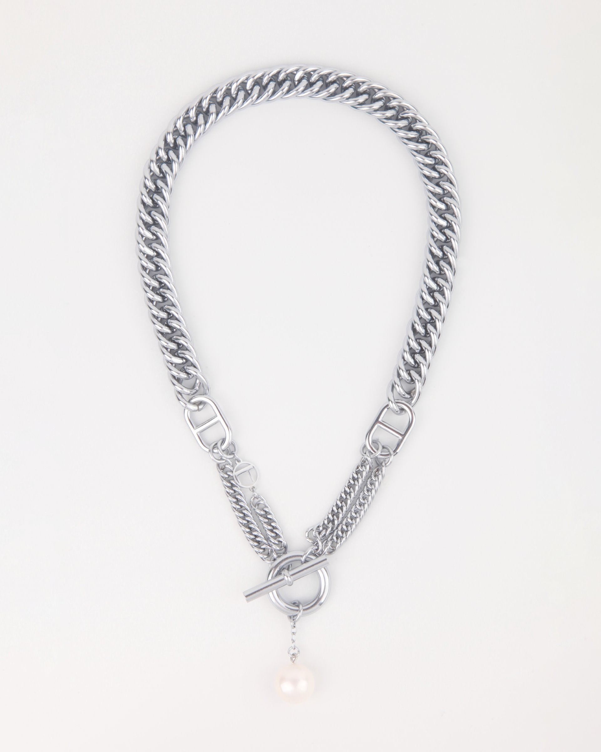 A silver chain necklace with a chunky flat-curb interwoven design. It features a toggle clasp and a single dangling freshwater pearl charm, creating a blend of elegance and modern style. The Girlfriend Necklace by For Art's Sake® is displayed on a plain, light background.